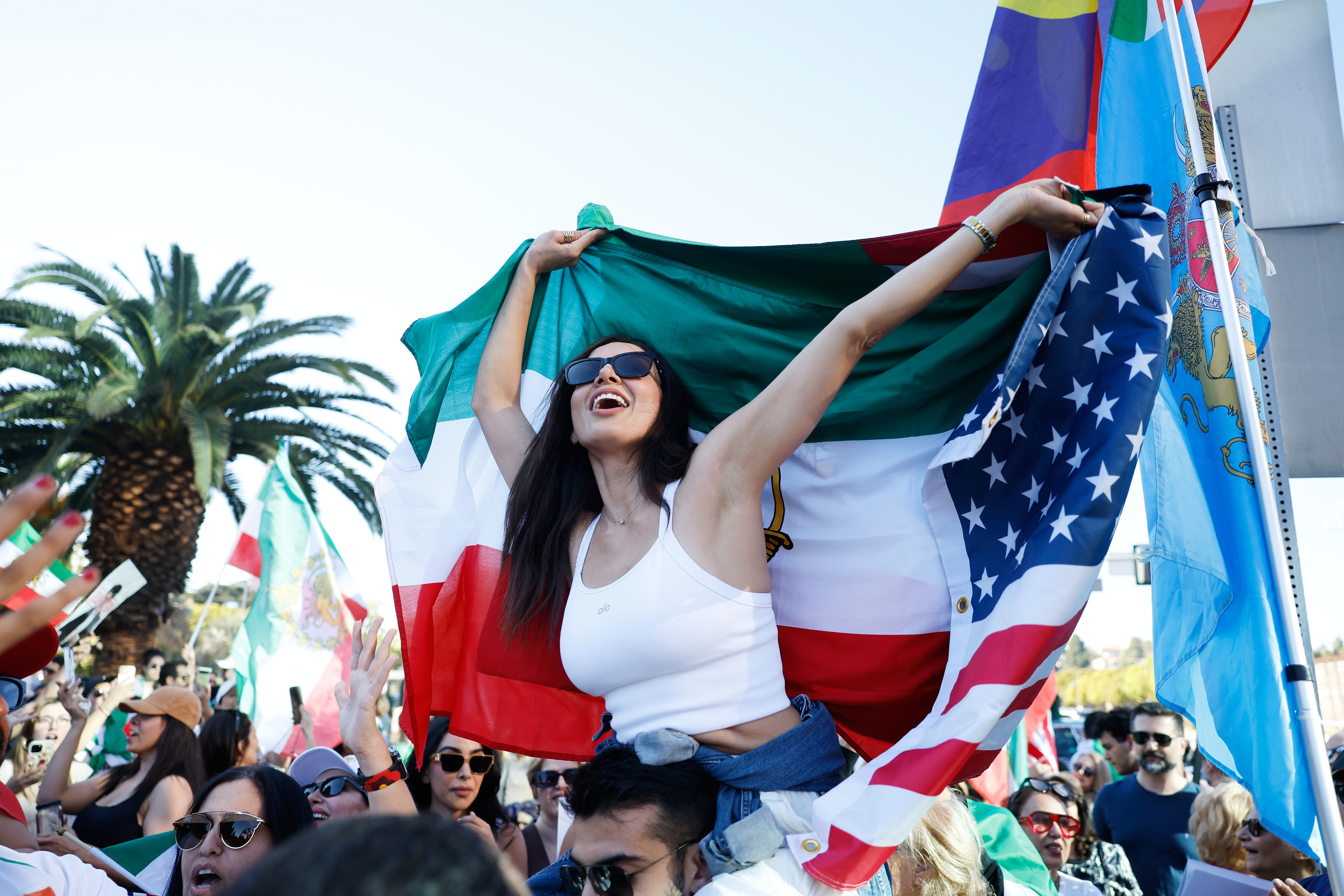 People hold flags during a demonstration in reaction to the...