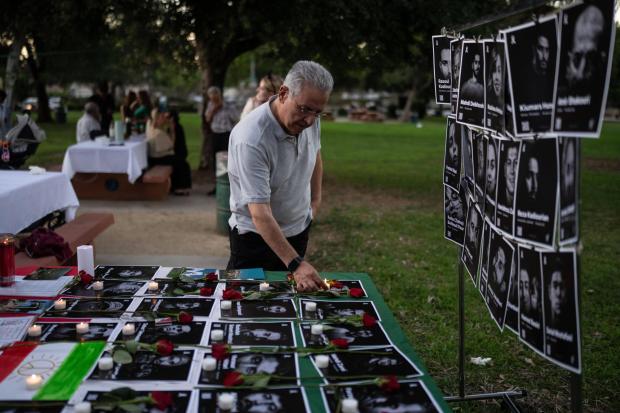 Geev Lameh places a candle by photos described as Iranian protesters killed in January, during a community gathering ahead of the Nowruz holiday in the Encino neighborhood of Los Angeles, March 17, 2026. (AP Photo/Jae C. Hong)