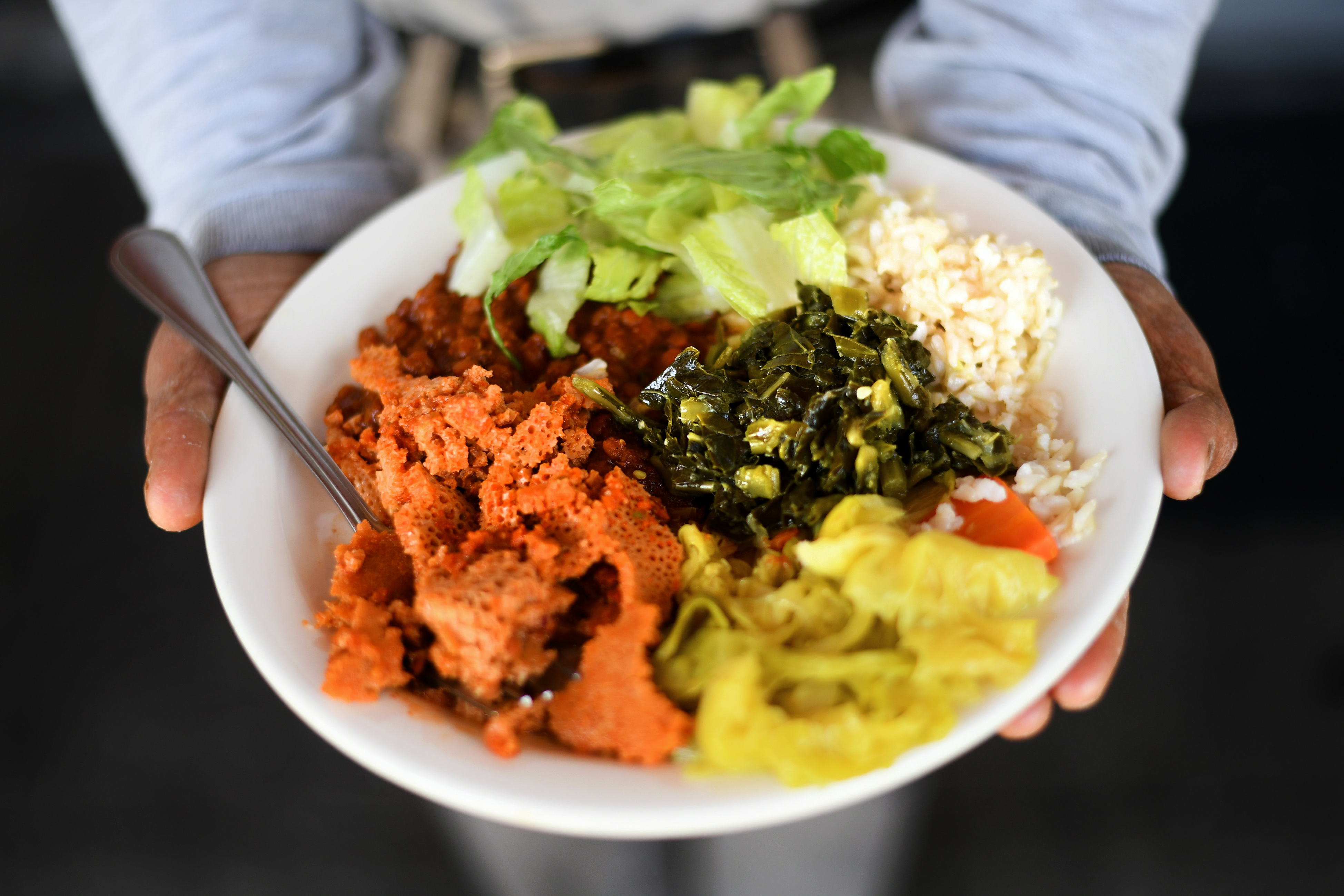 Owner Wondu Haile presents a mixed plate of dishes from...