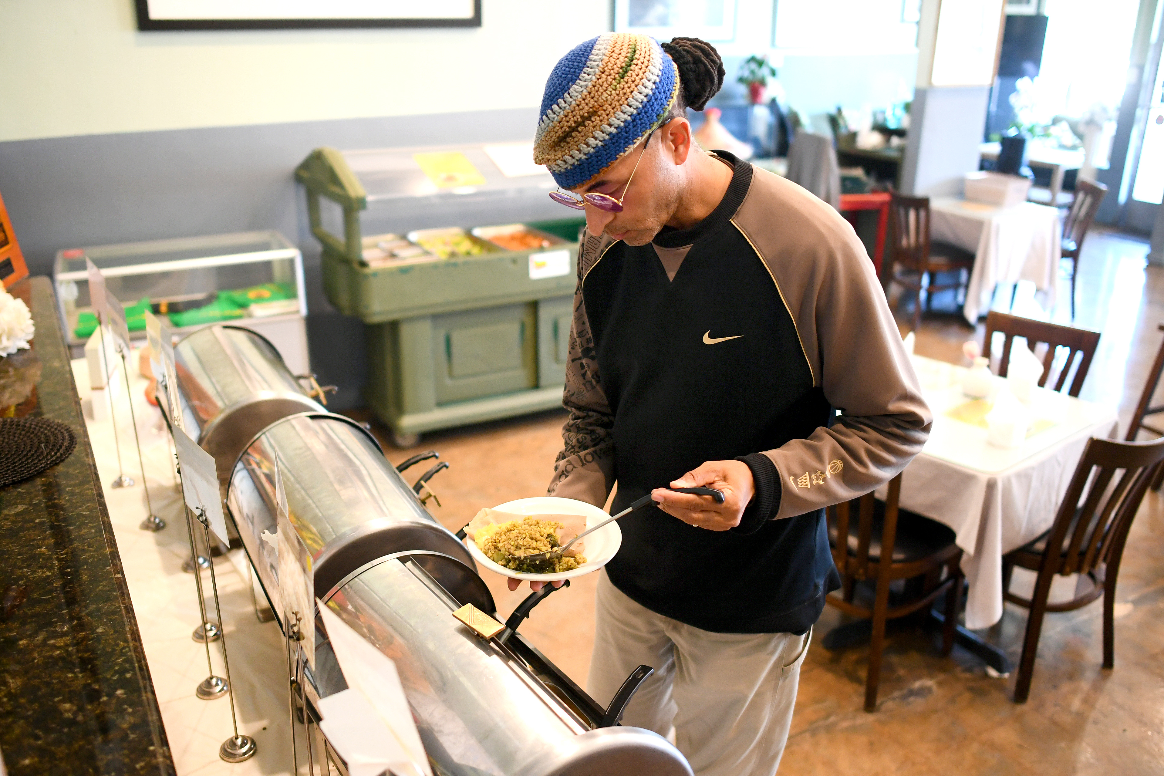 Kenneth Beavers fills a plate at the vegan buffet at...