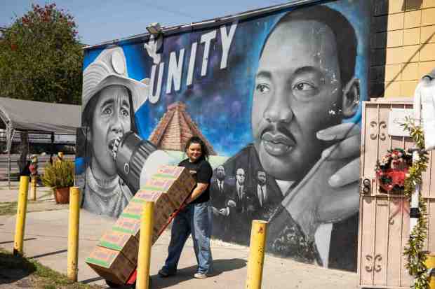 Mayte De La Vega, executive associate at Southern California Crossroads, prepares for a food bank as she passes a mural at Watts/Century Latino Organization on Monday, March 23, 2026 where Artist Mister Alek painted Dolores Huerta over César Chávez following sexual assault allegations against the labor leader. (Photo by Sarah Reingewirtz, Los Angeles Daily News/SCNG)