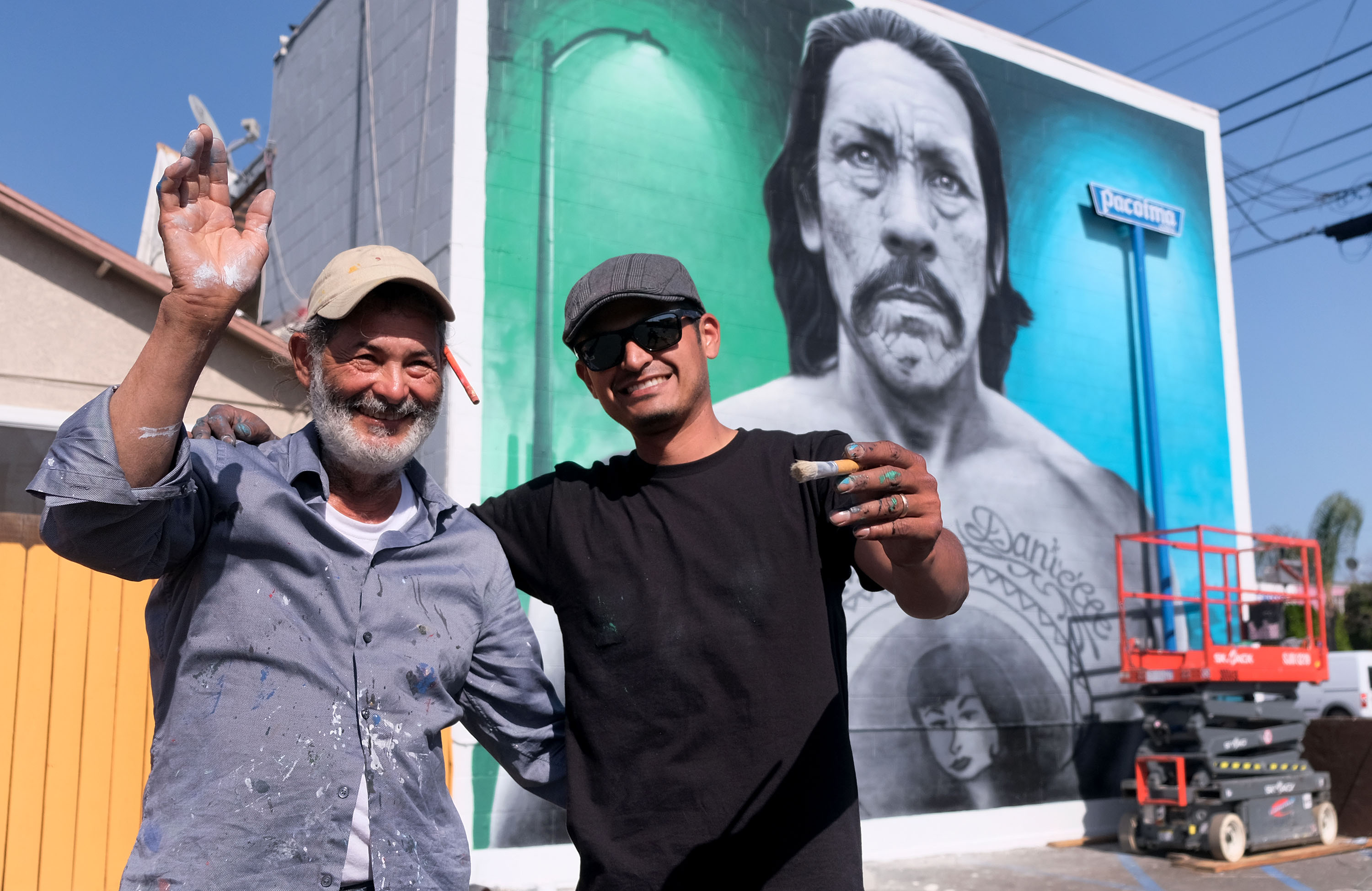 Juan Hector Ponce and muralist Levi Ponce, celebrate restoring the...