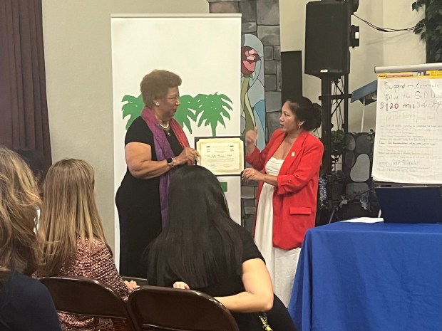 Nancy Jones (left), president of the La Jolla Woman's Club, receives the La Jolla Town Council's Women of Impact award on the group's behalf from council President Mary Soriano. (Noah Lyons)