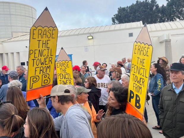 Protesters hold signs at an Oct. 9 rally outside the Pacific Beach/Taylor Library opposing a planned 239-foot-tall residential-commercial building in north Pacific Beach. (Noah Lyons)