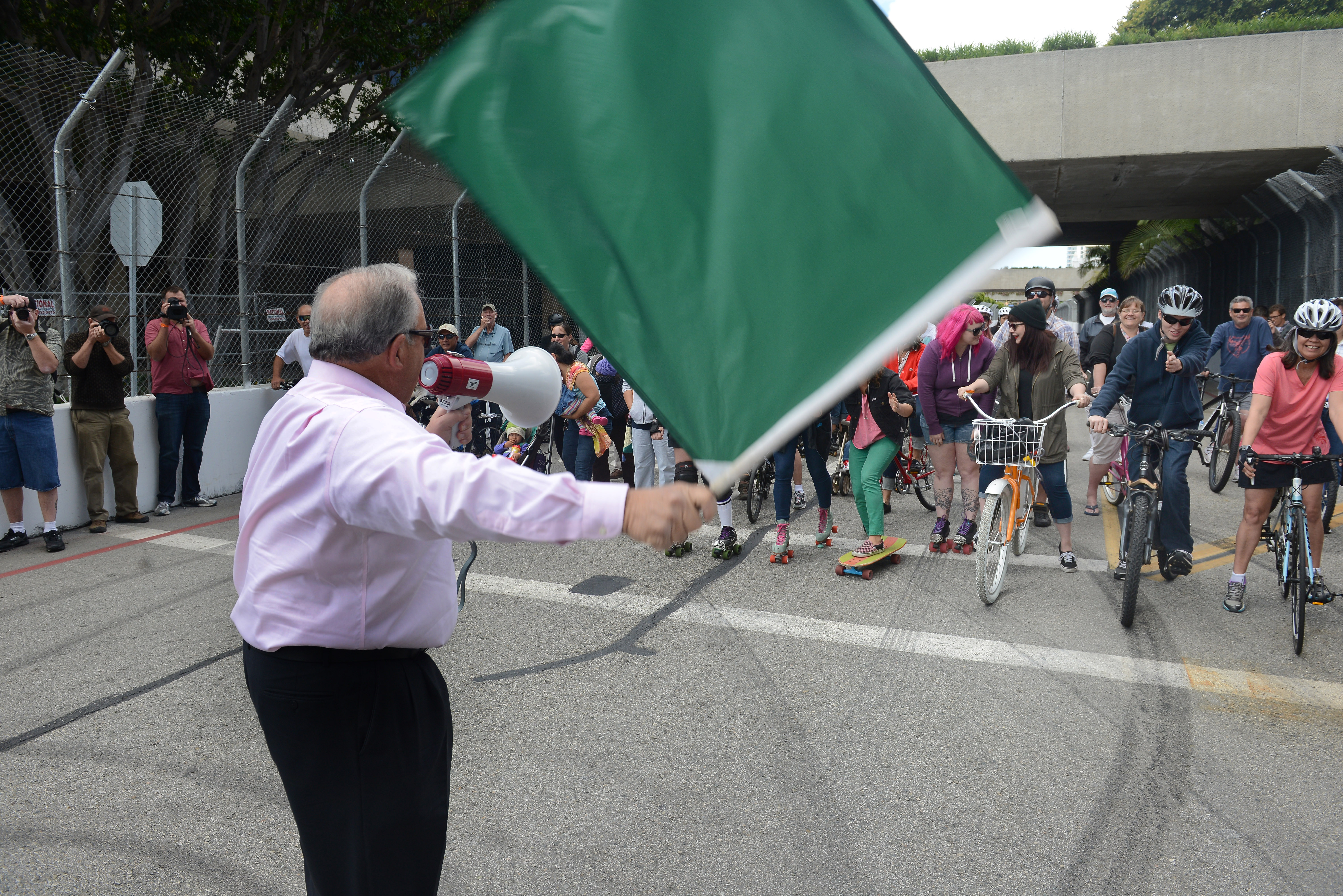 Mayor Bob Foster waves the starting flag for bikers who...