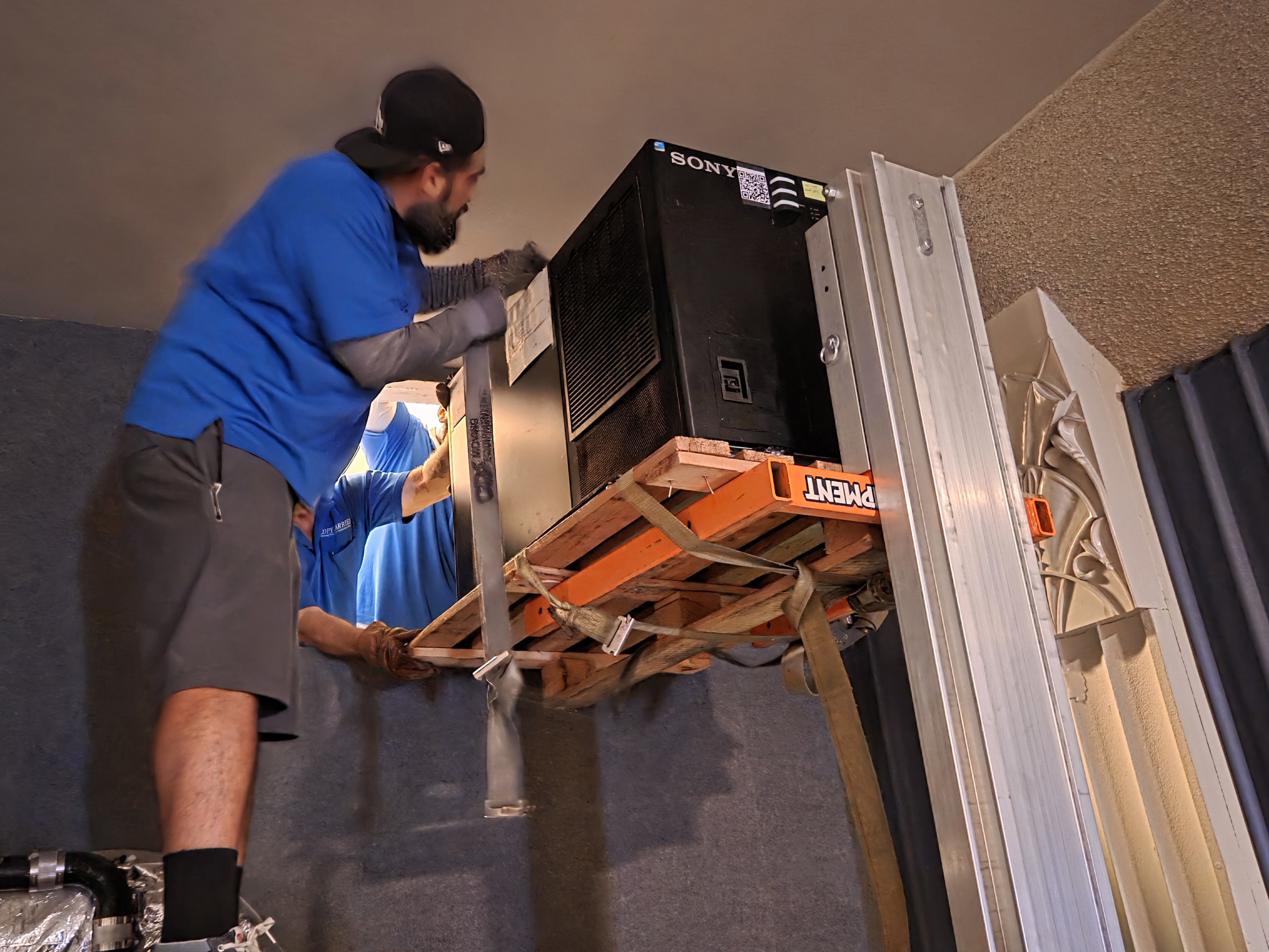 Workers install a new 4K projector at The Art Theatre...