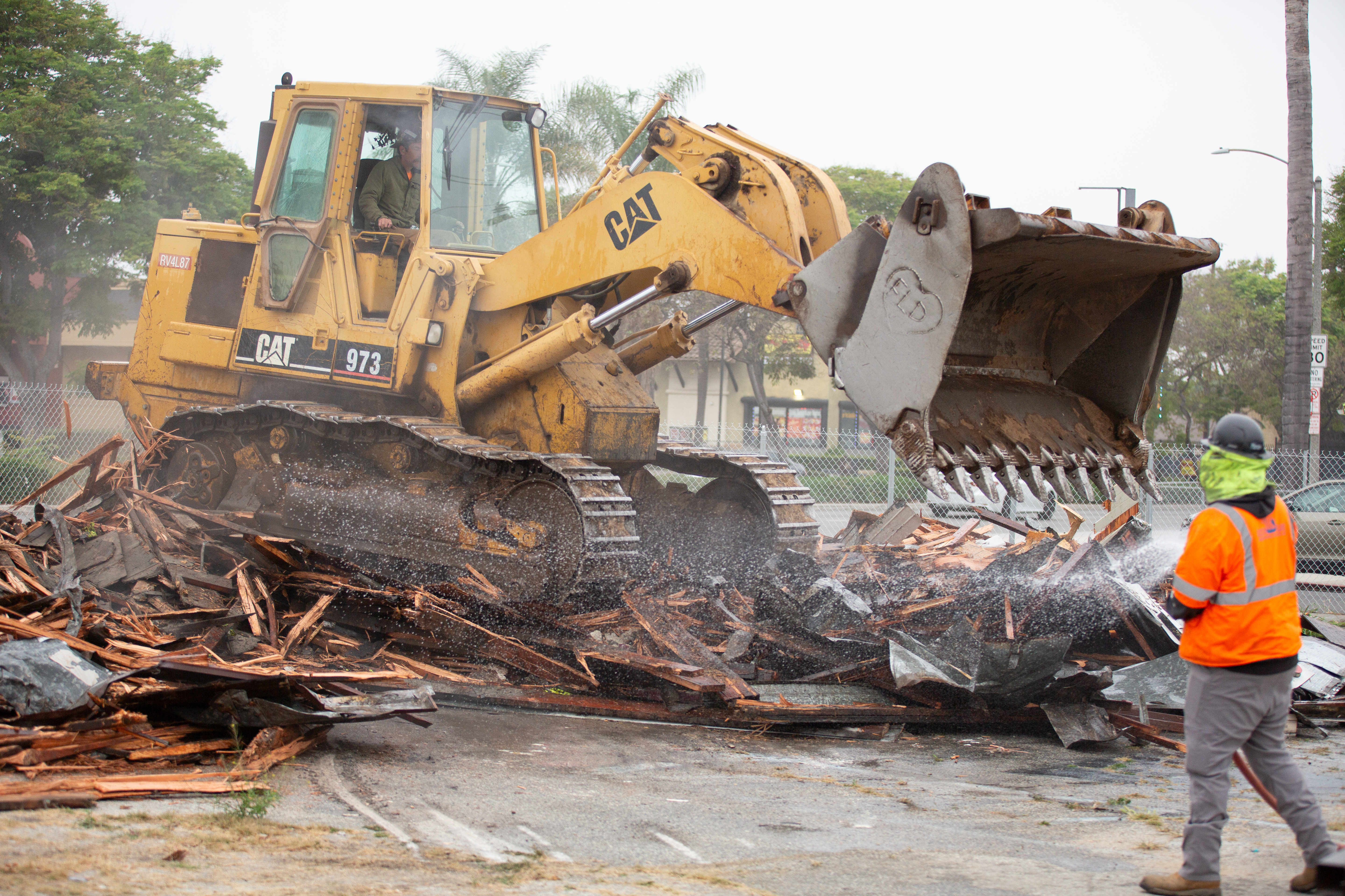Work crews demolish an abandoned fast food restaurant and gas...