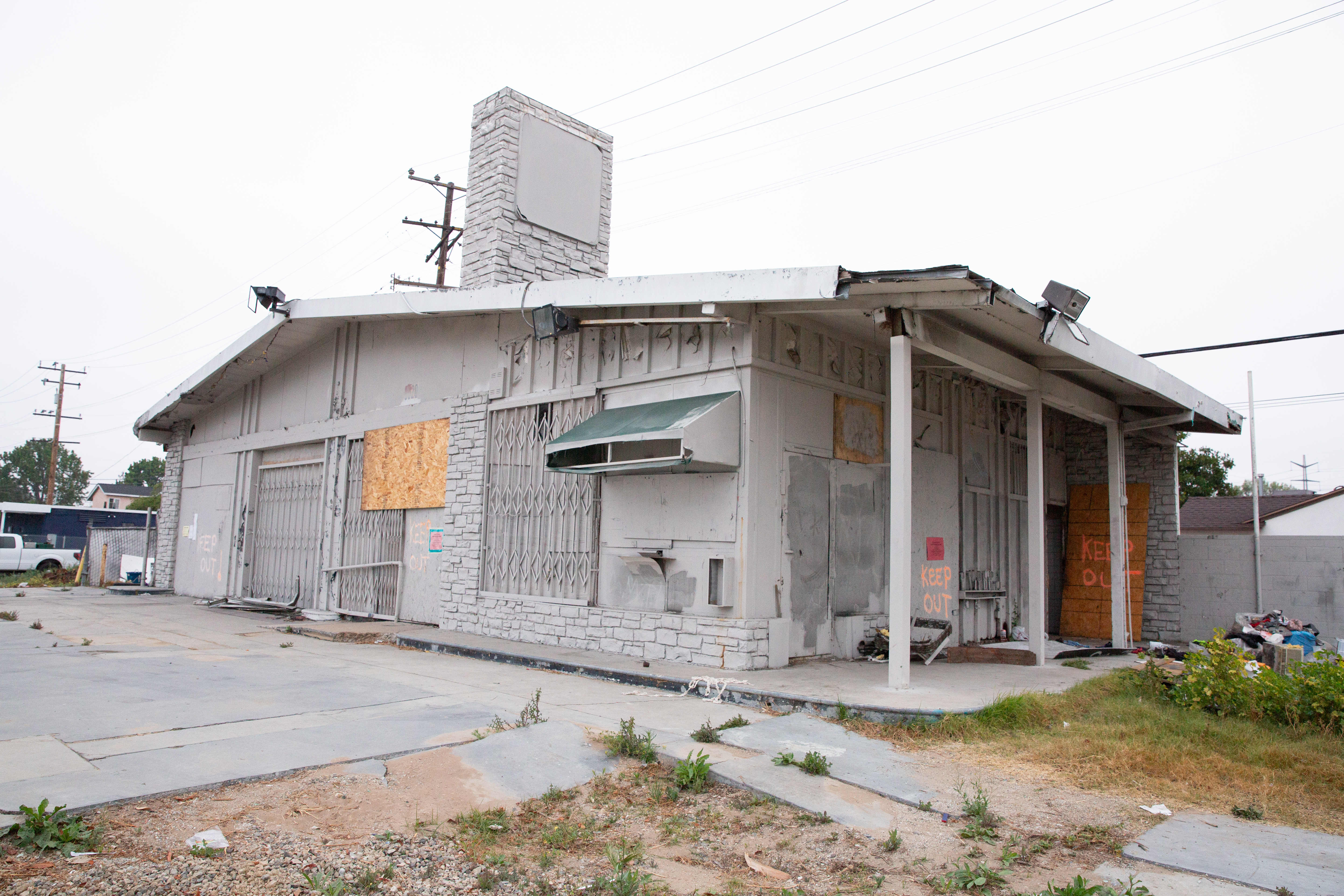 An abandoned gas station sits boarded up just before it...