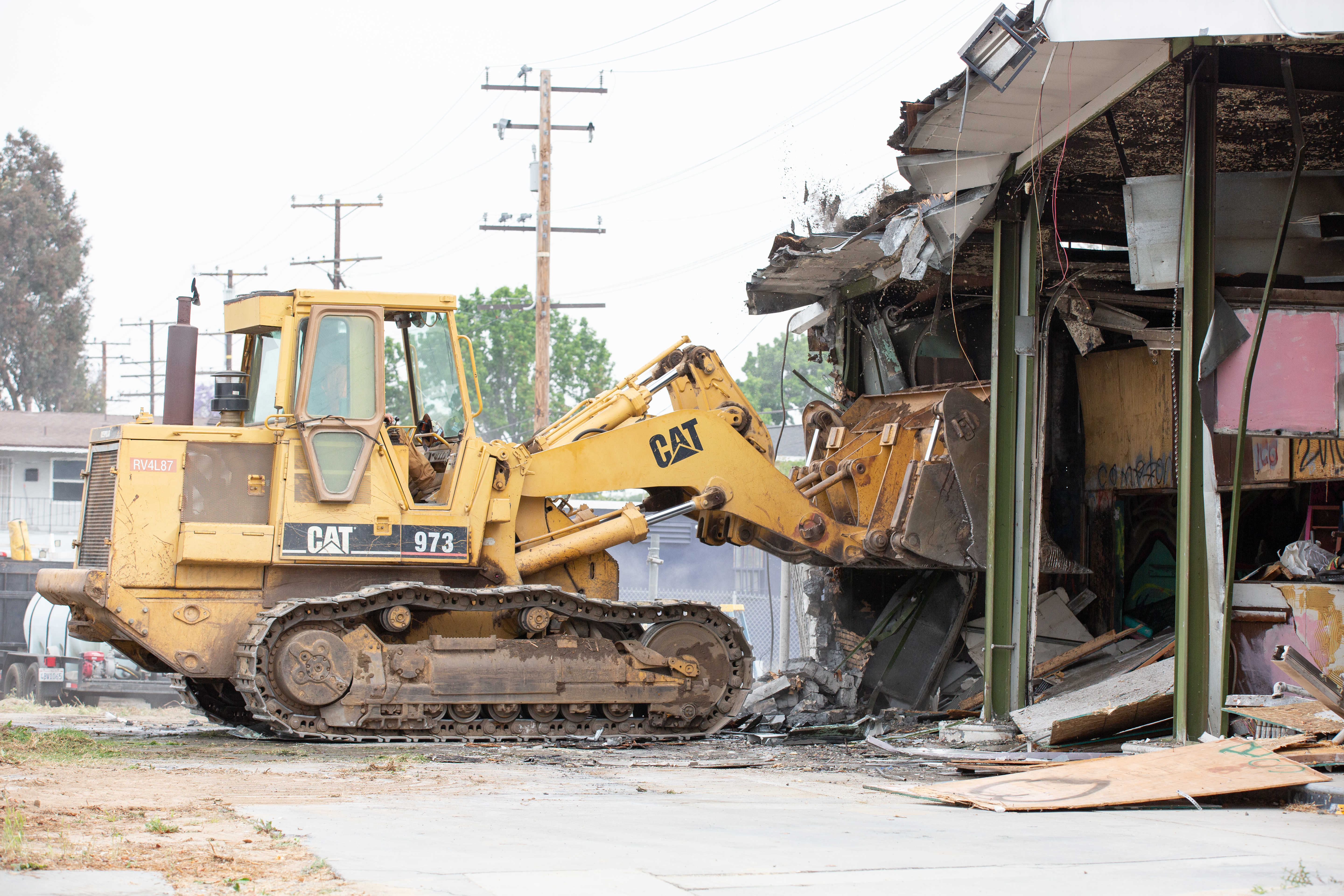 Work crews work to demolish an abandoned fast food restaurant...