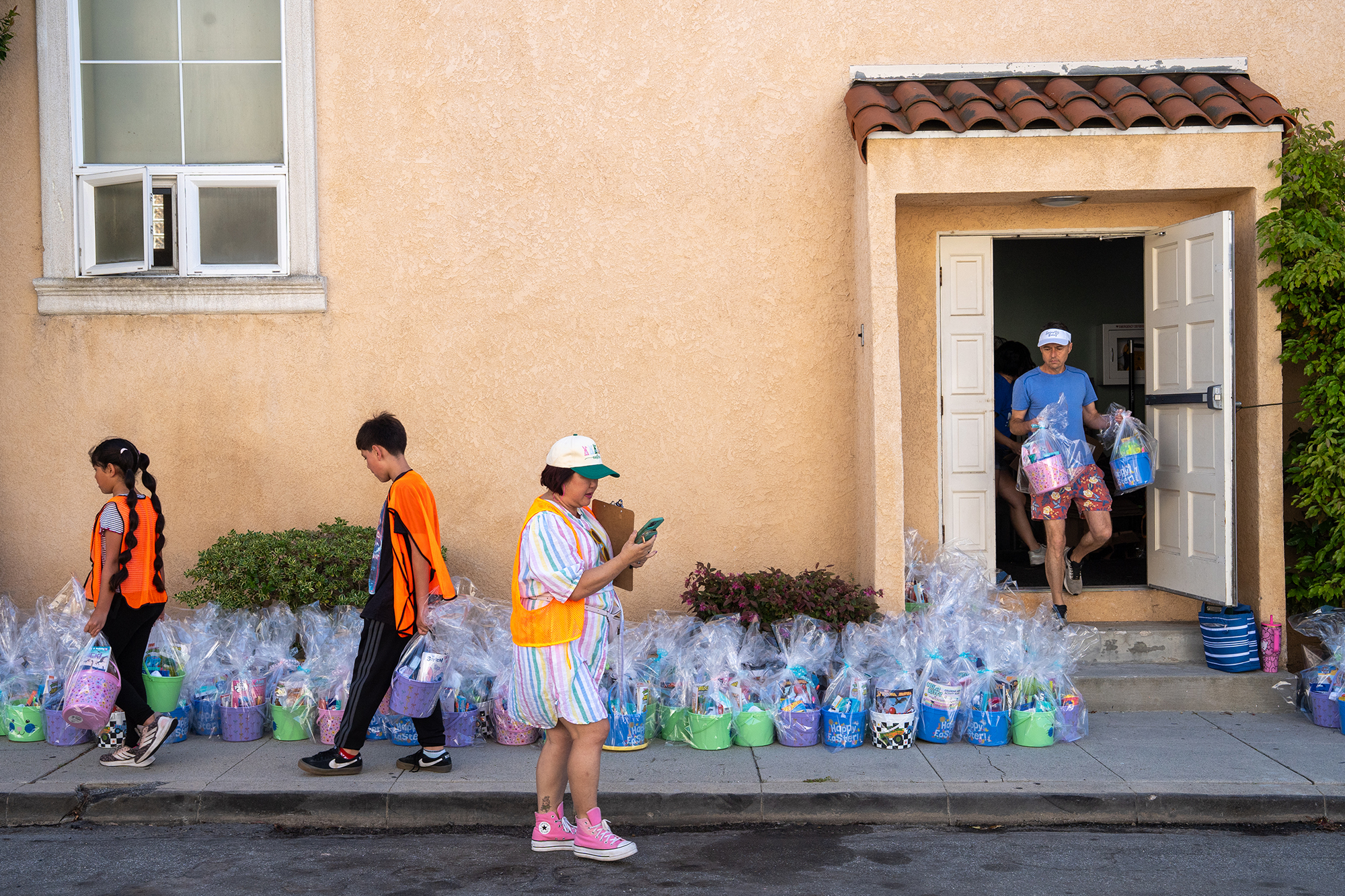 Volunteers carry baskets from inside the church to the sidewalk...