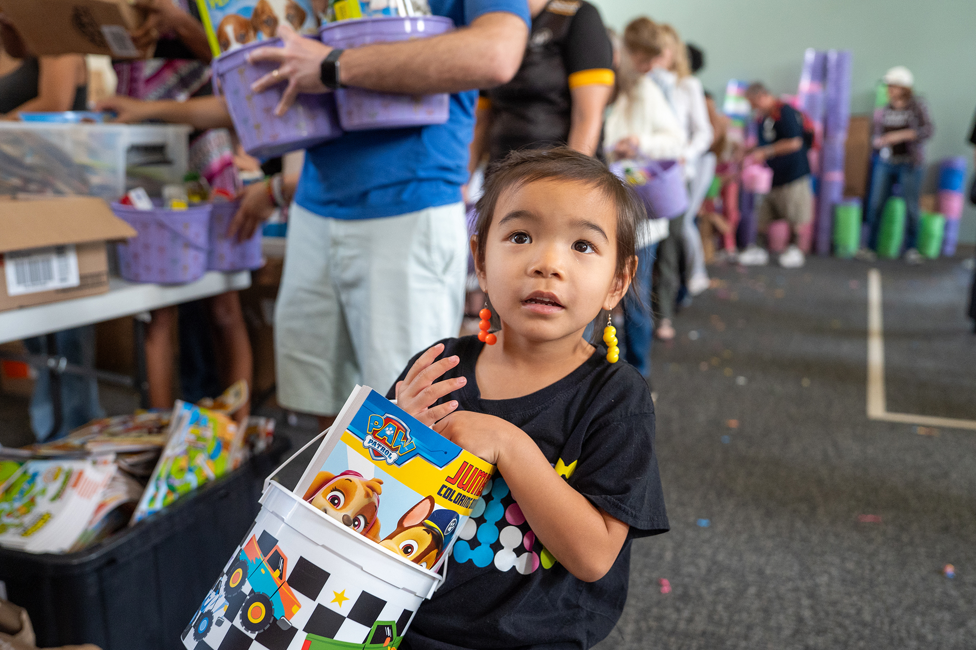 A young girl holds an Easter gift basket she is...