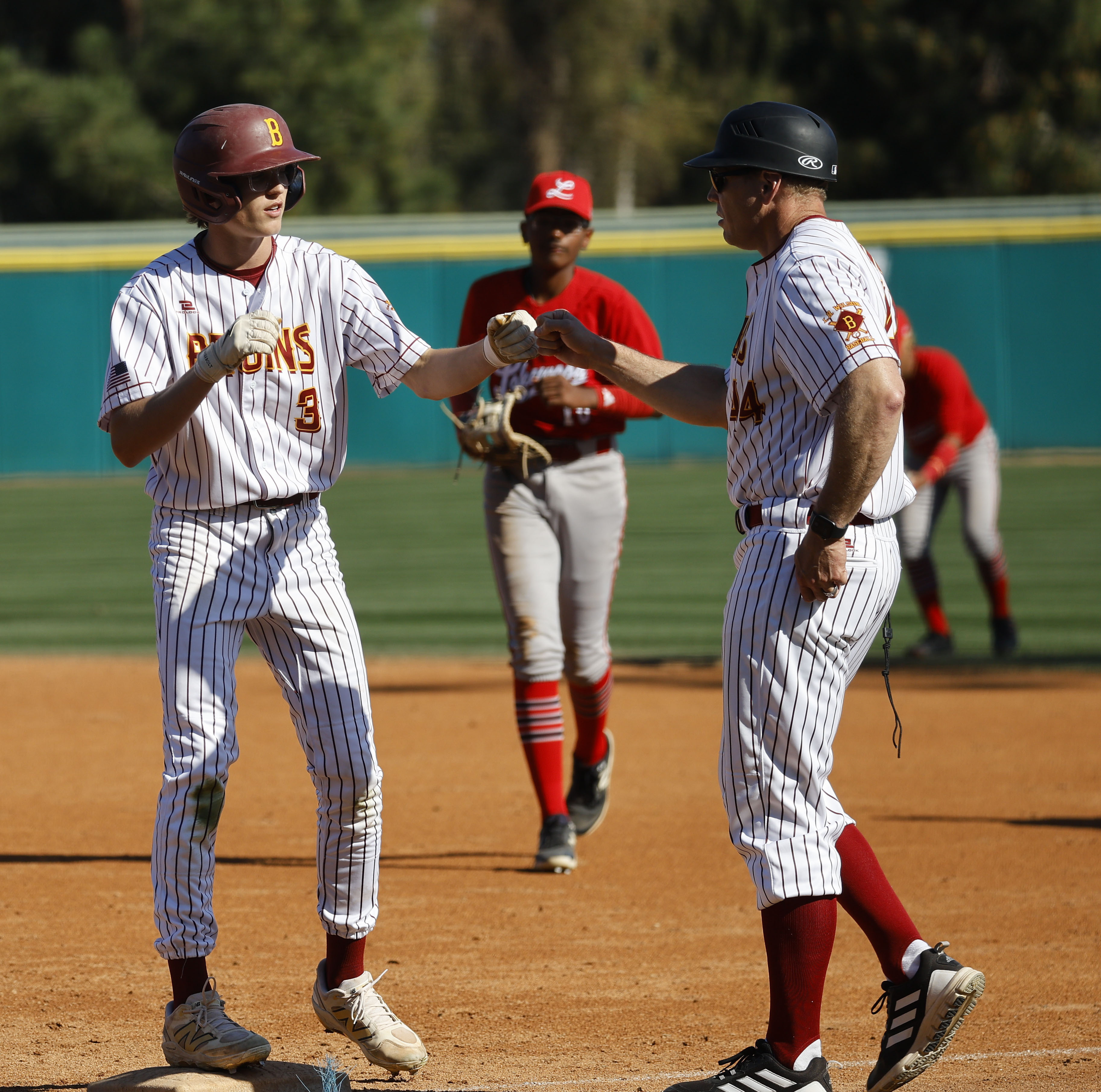 Wilson’s Cooper George fist bumps his first base coach as...