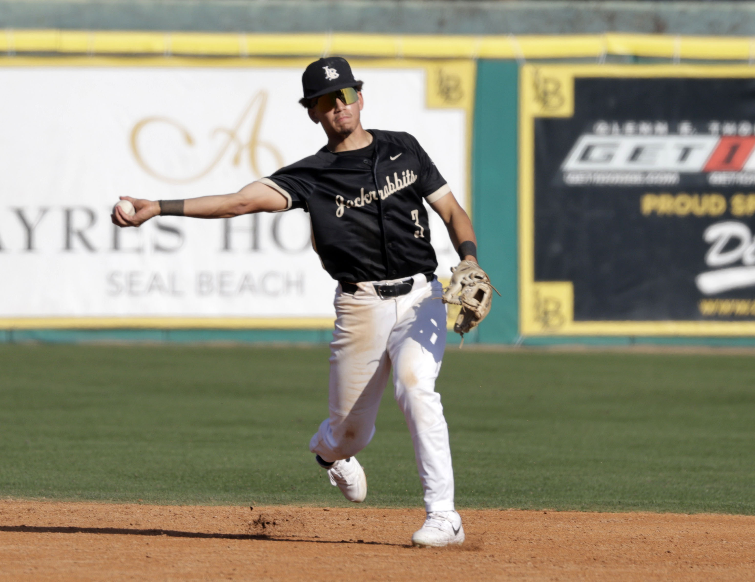 Long Beach Poly’s Tate Hammond (3) throws to first as...