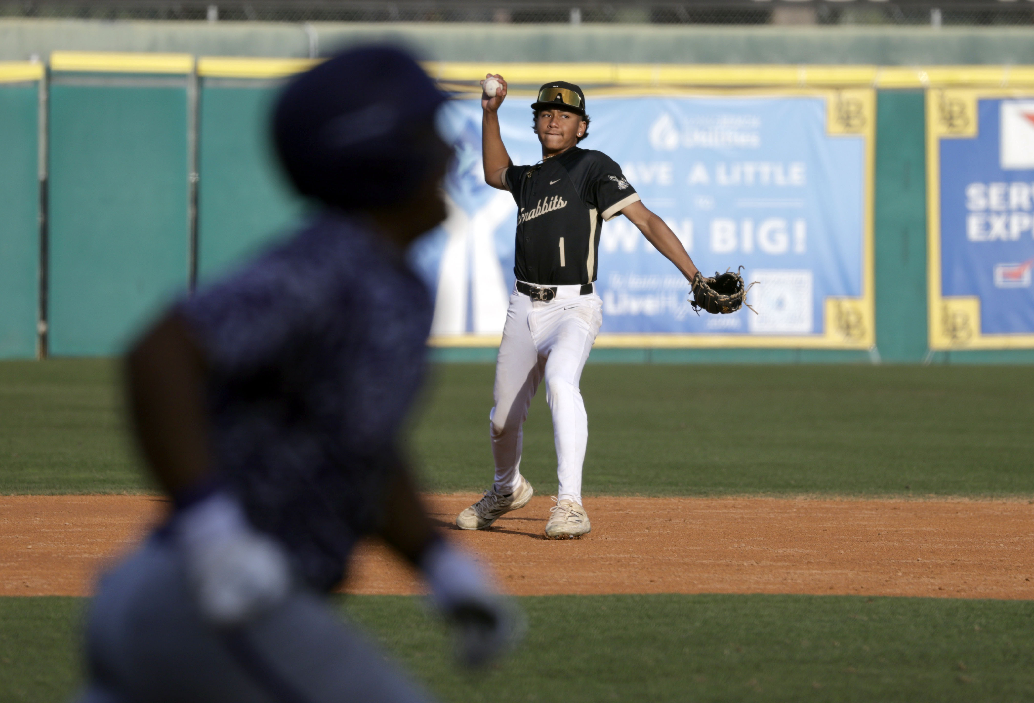 Long Beach Poly’s Braylen Reyes (1) looks to throw the...