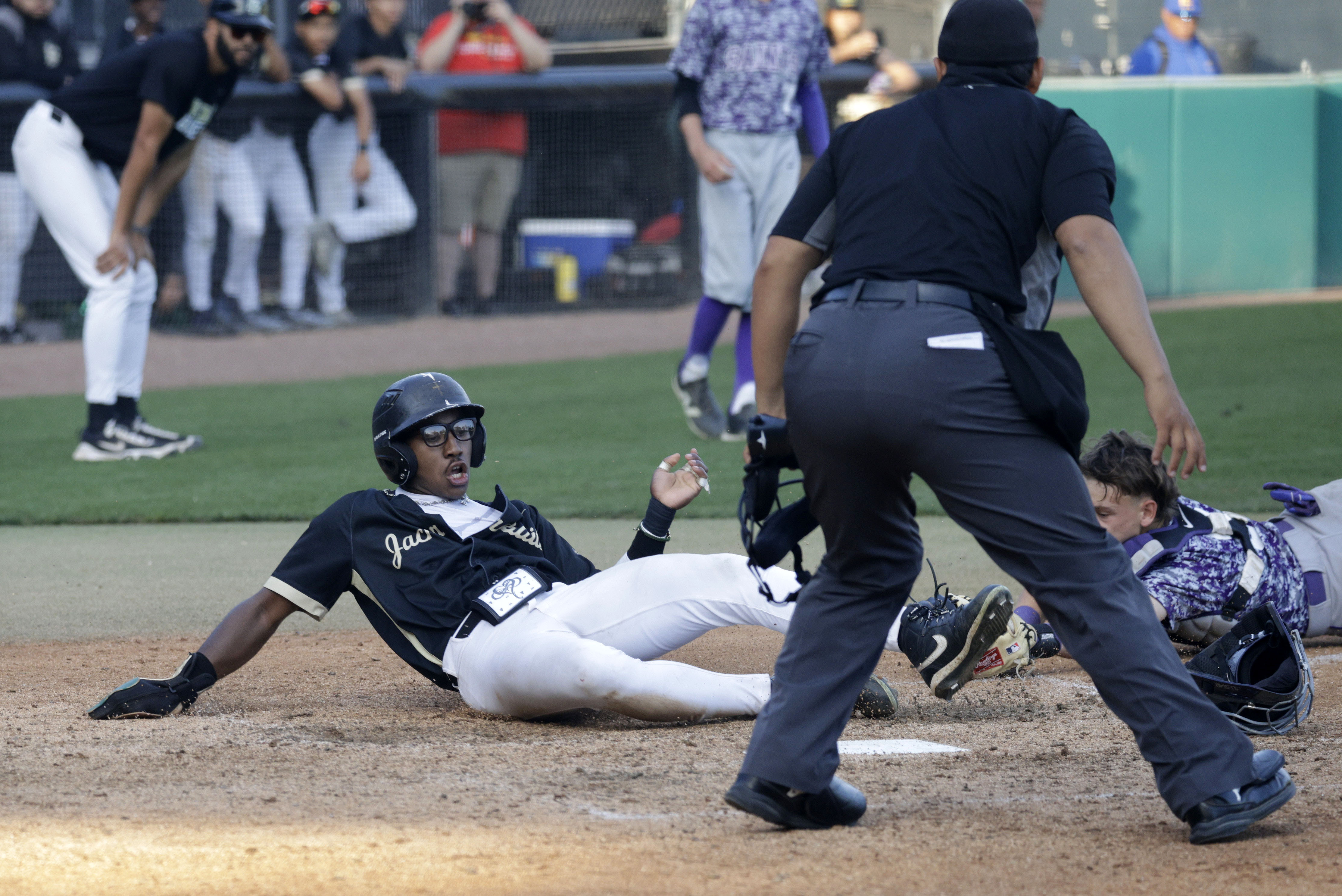 Long Beach Poly’s Freddie Parish (5) slides into home past...