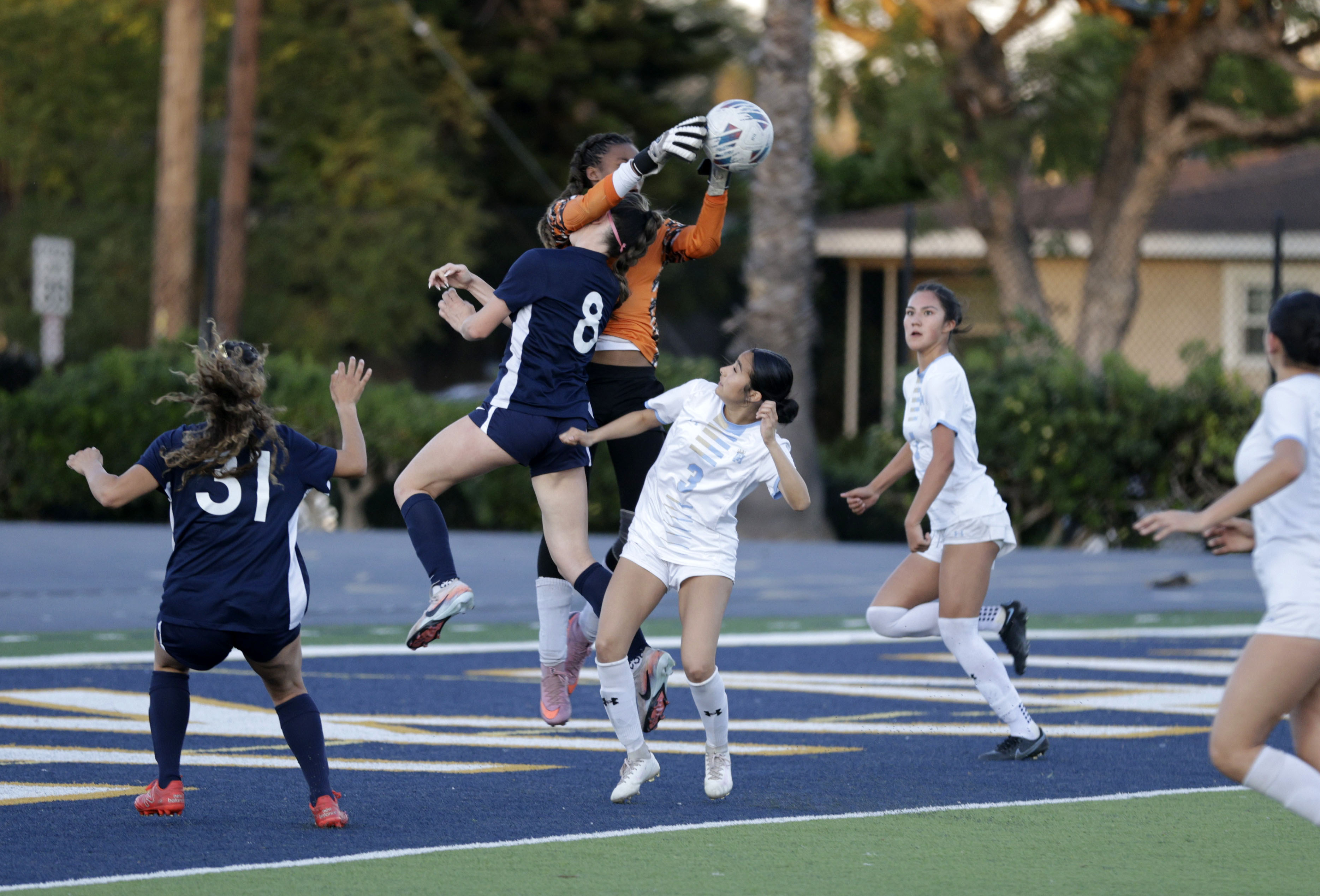 Millikans Adeline Murphy (8) collides with Quartz Hills goalie Lelani...