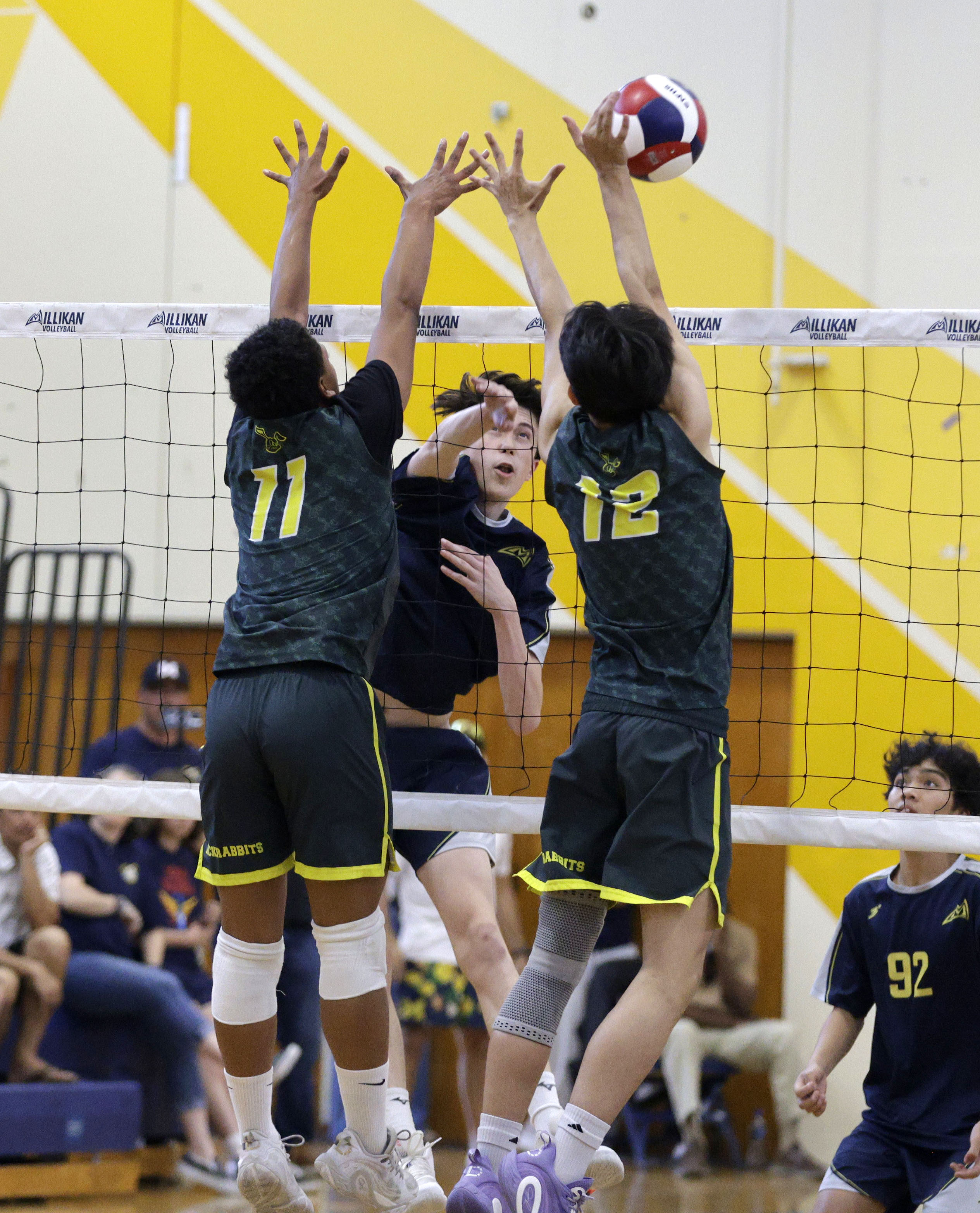 Millikan’s Dominic Tirado (11) tires to hit the ball past...