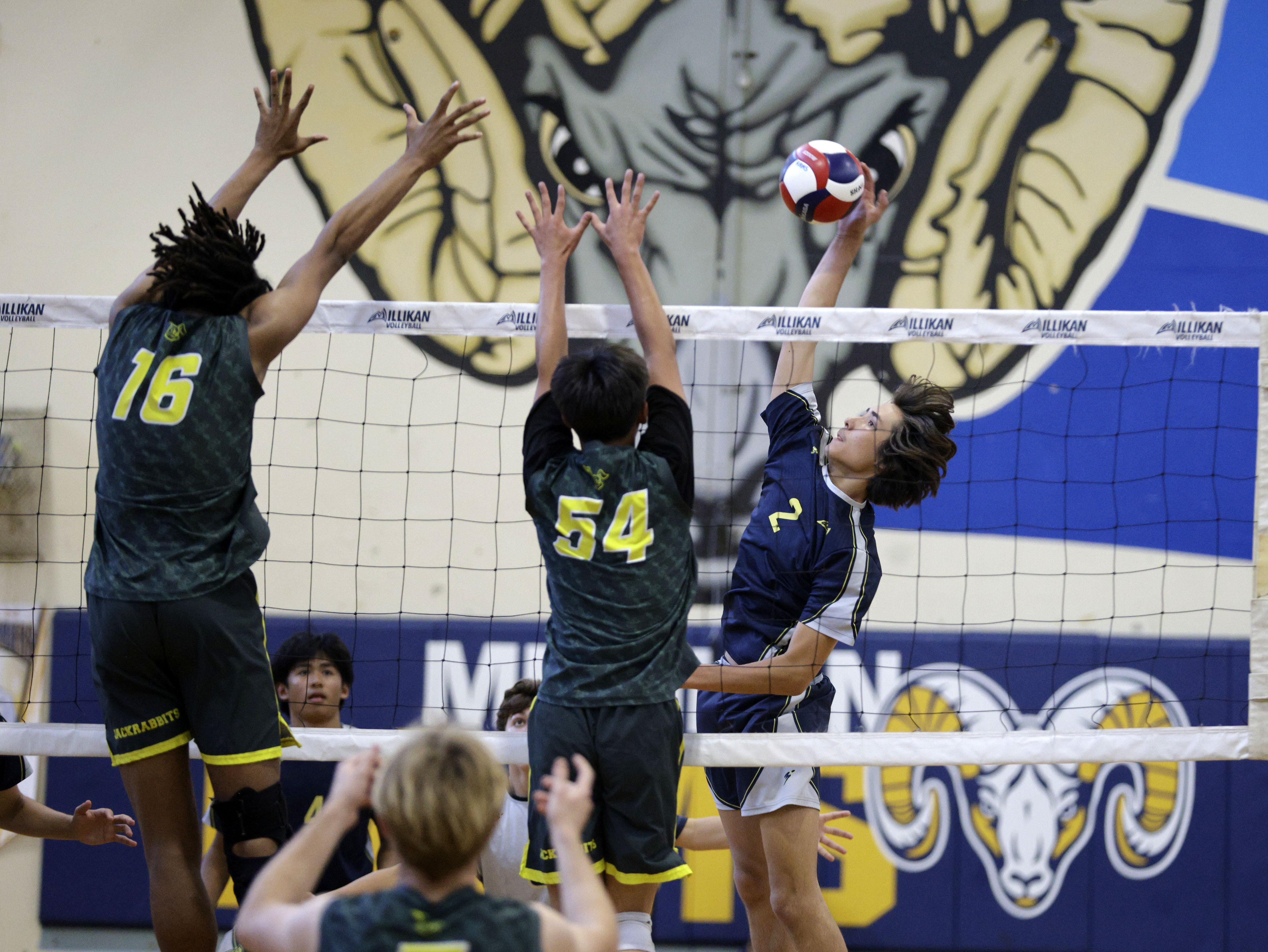 Millikan’s Will Cordova (2) looks to hit the ball past...