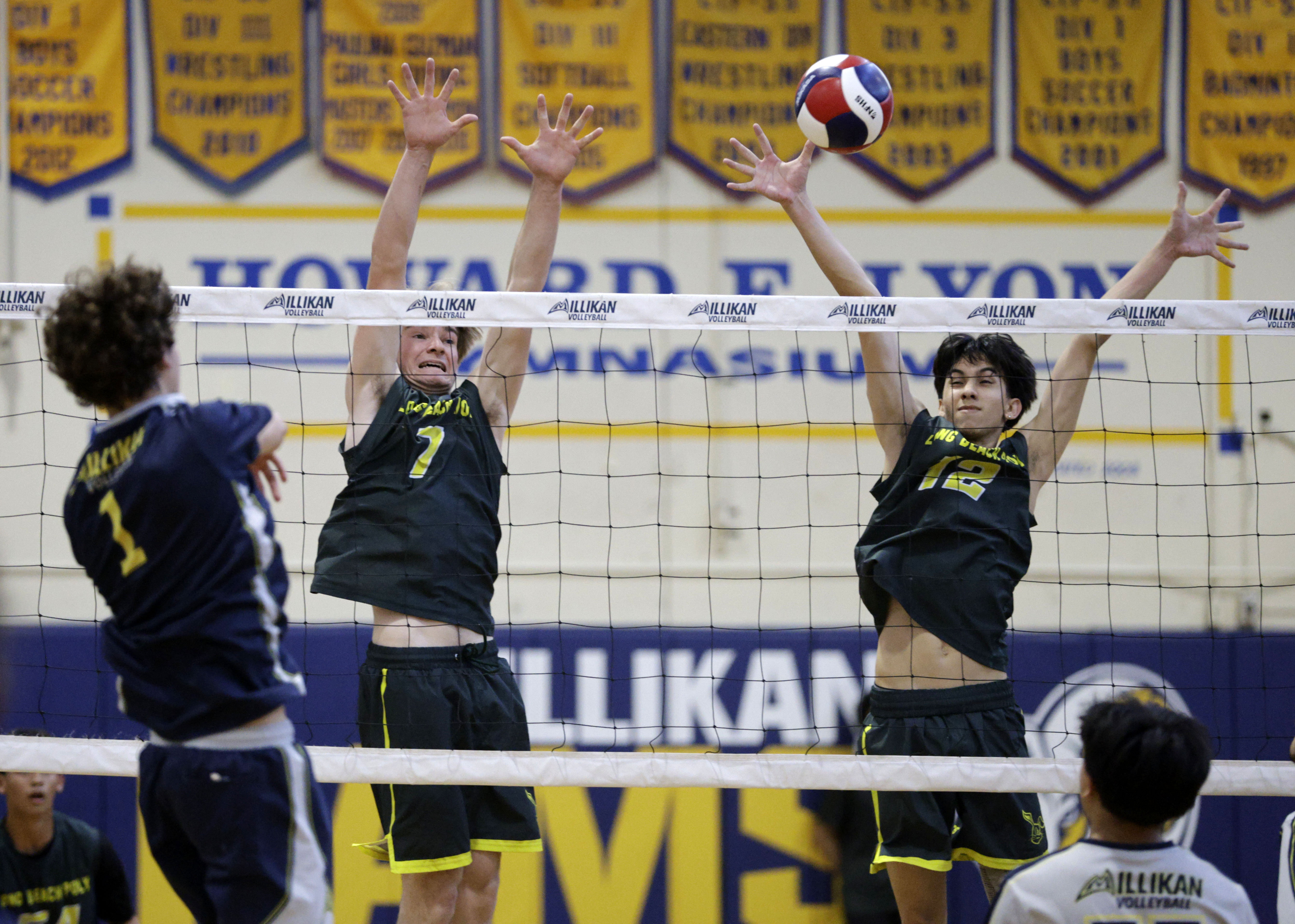 Millikan’s Jacob Karkanen (1) hits the ball over to Long...