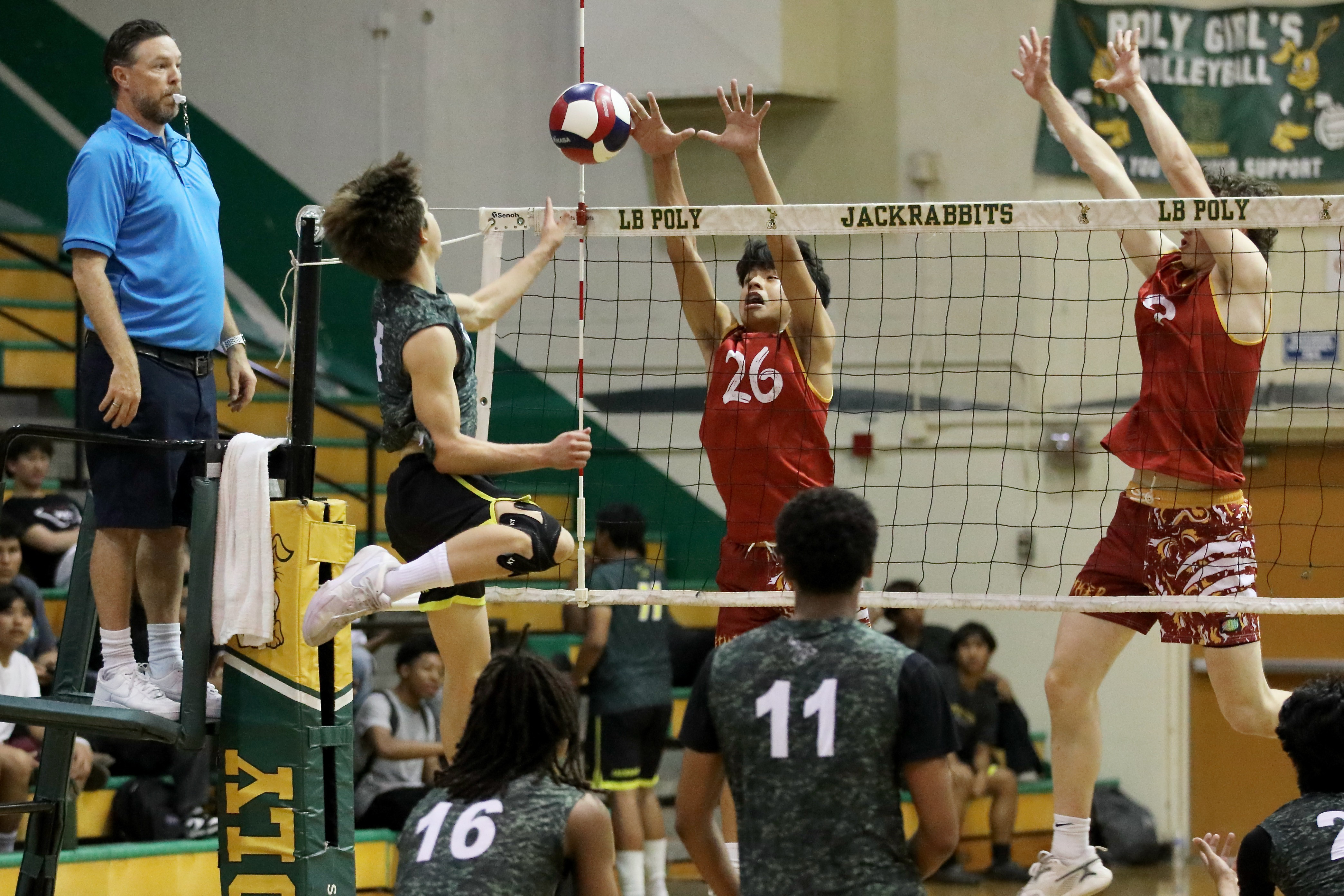 Long Beach Poly outside hitter Nicholas Frank, left, eases the...