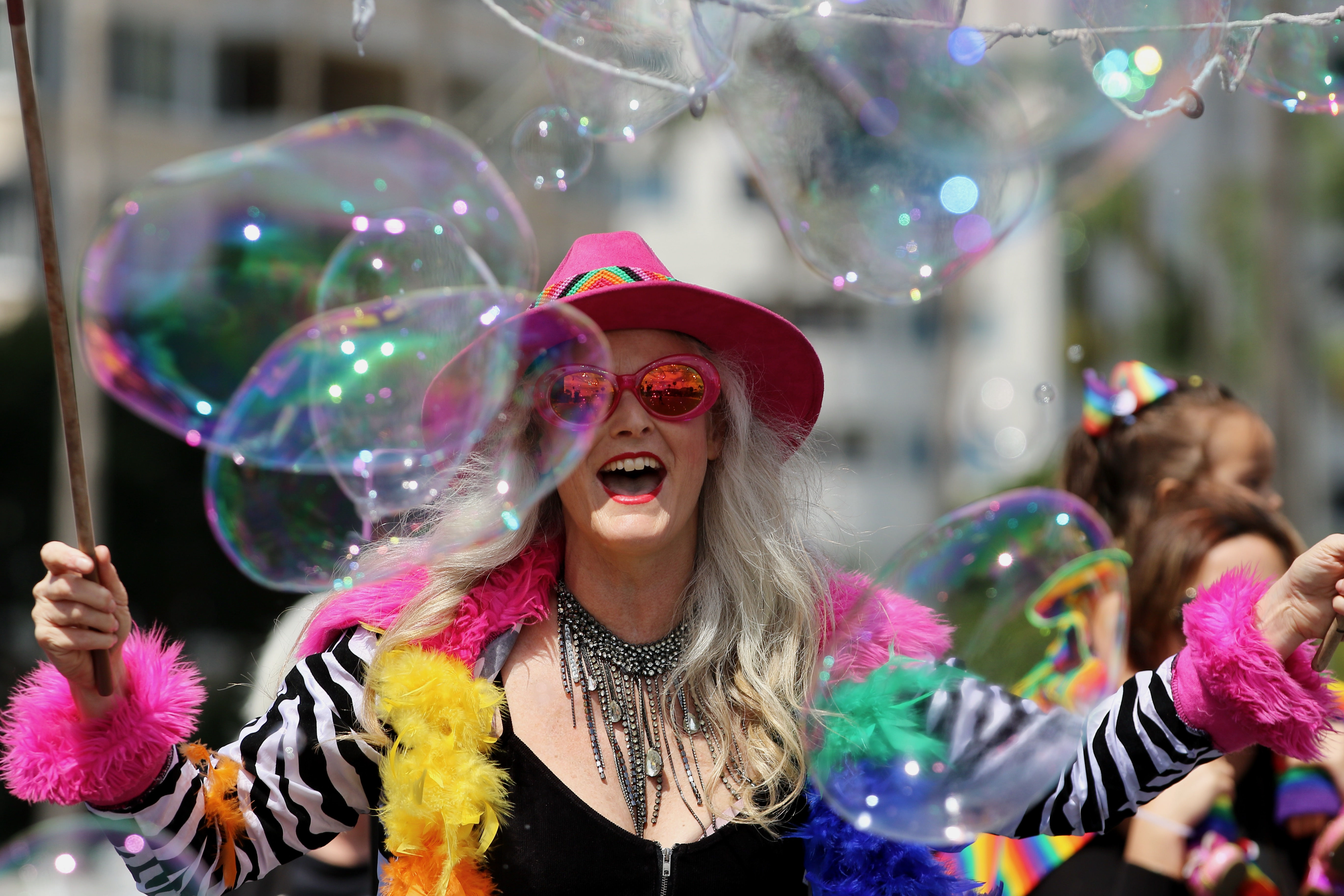 A spectator views the Long Beach Pride Parade through large...