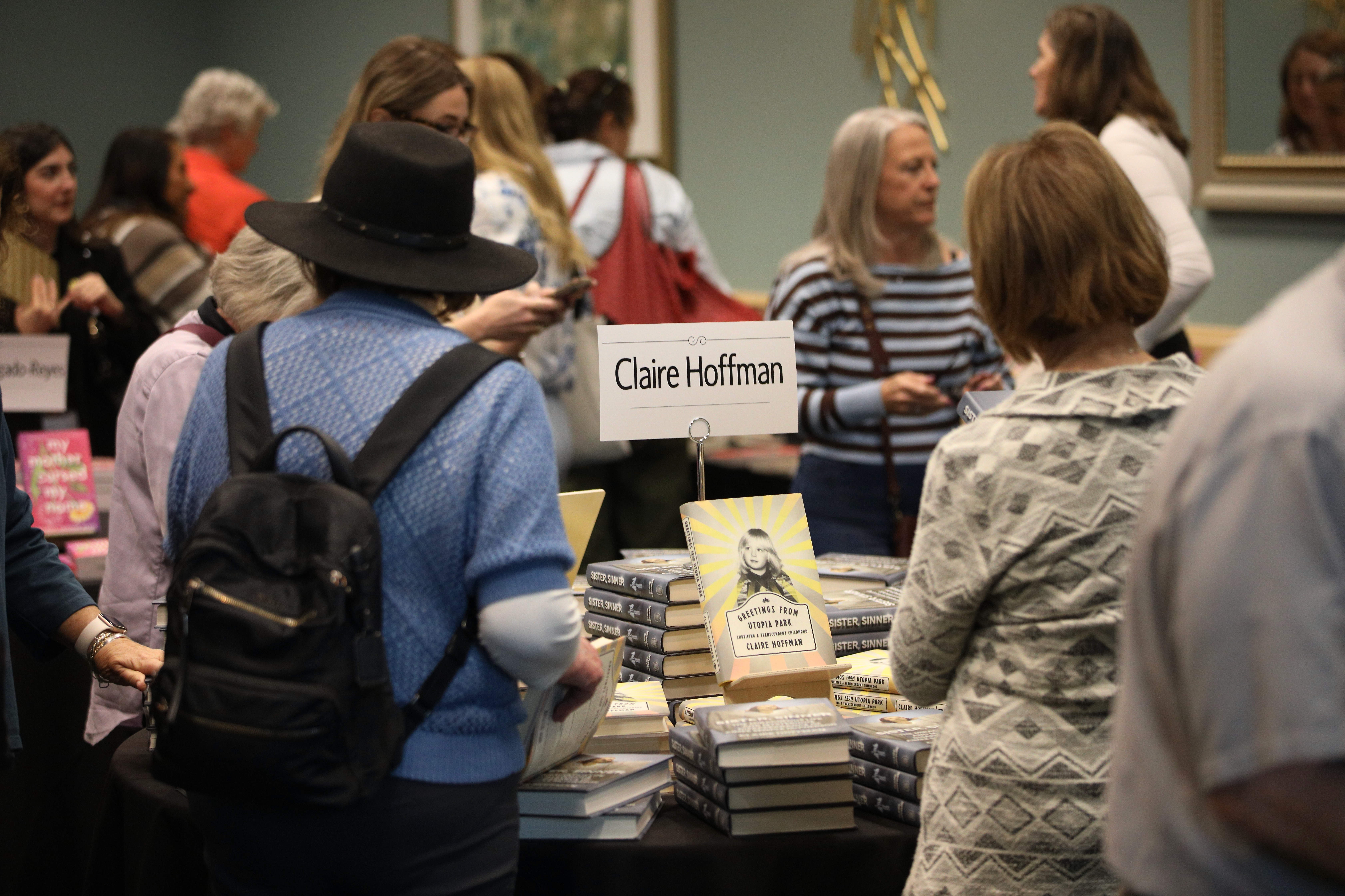 Attendees peruse books written by participating authors at the annual...