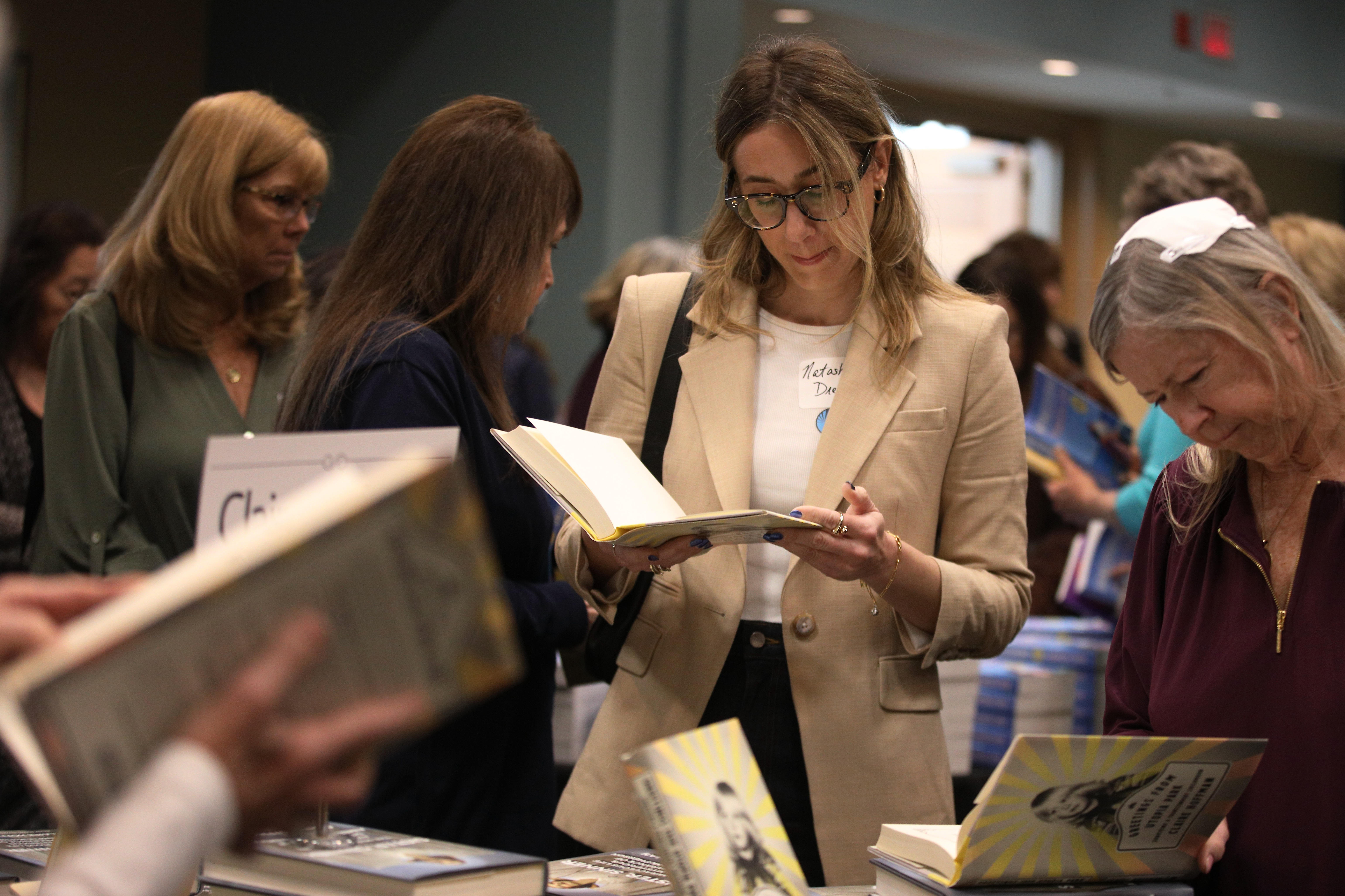 Attendees peruse books written by participating authors at the annual...