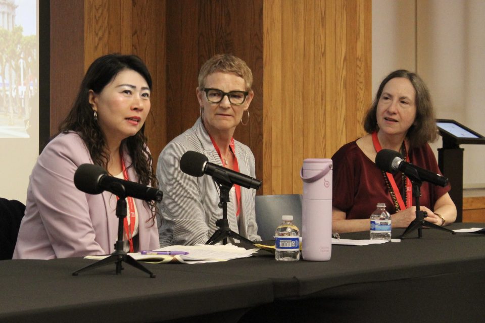 MLS alums Lucy Dong (left) and Rosalie Lack (center) sit a table with microphones in front of them with the Associate Dean of the MLP Program Jessica Vapnek (right).