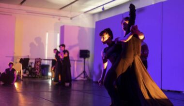 Ballet dancers rehearsing against a purple backdrop.