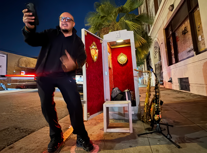 a man in front of a mini theater doing spoken word