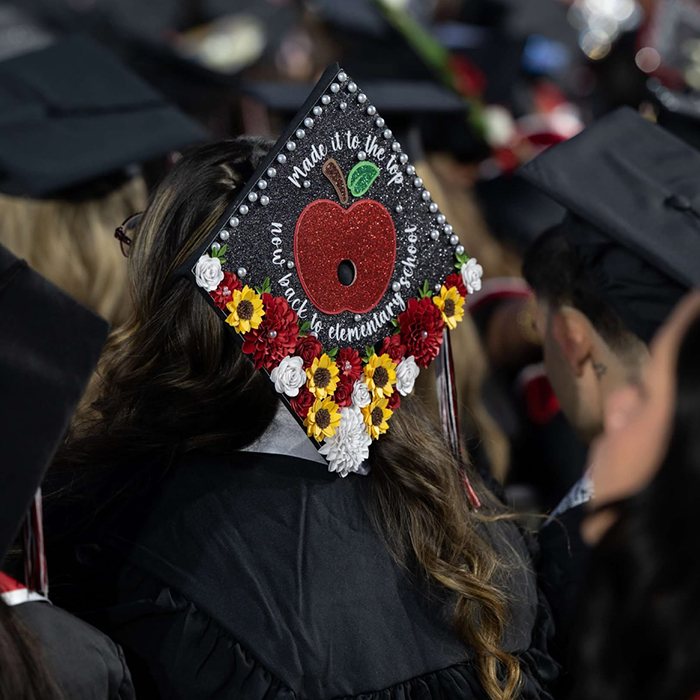 BC graduate cap featuring an beeded apple on it