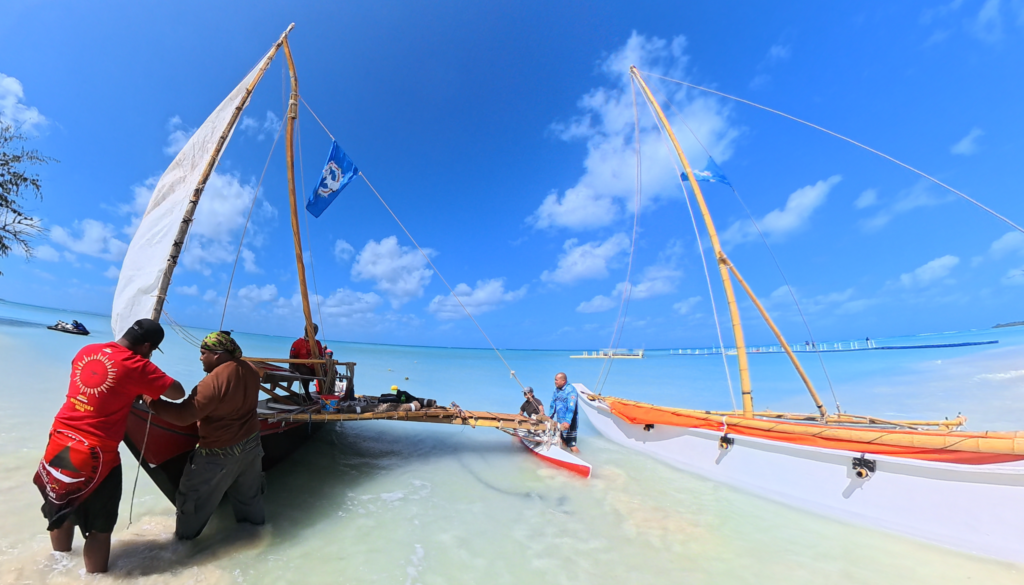 Crew members prep two traditional canoes to go sailing in clear waters in the Mariana Islands