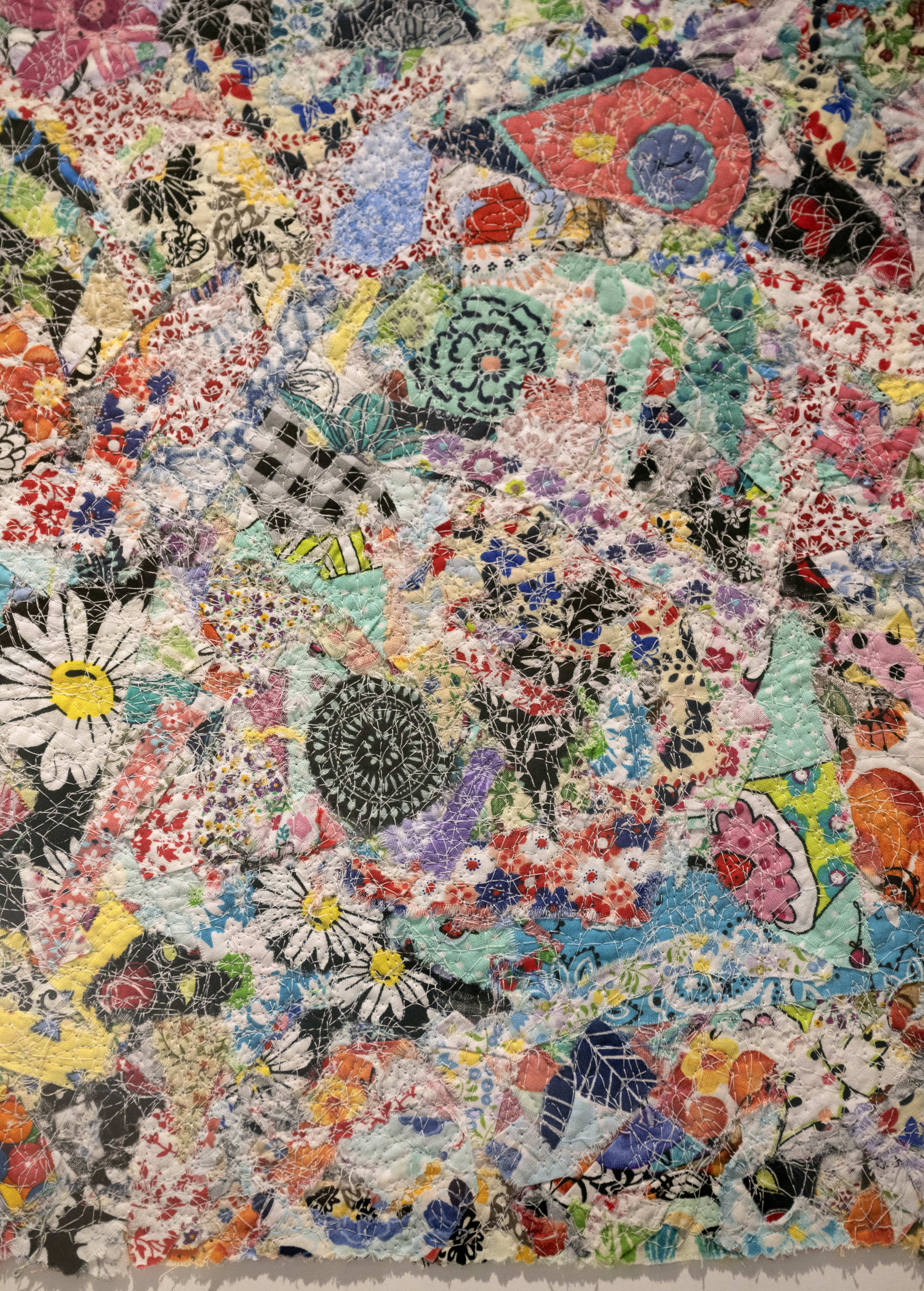 Local art, like this framed tapestryÂ of reclaimed fabrics and threads...