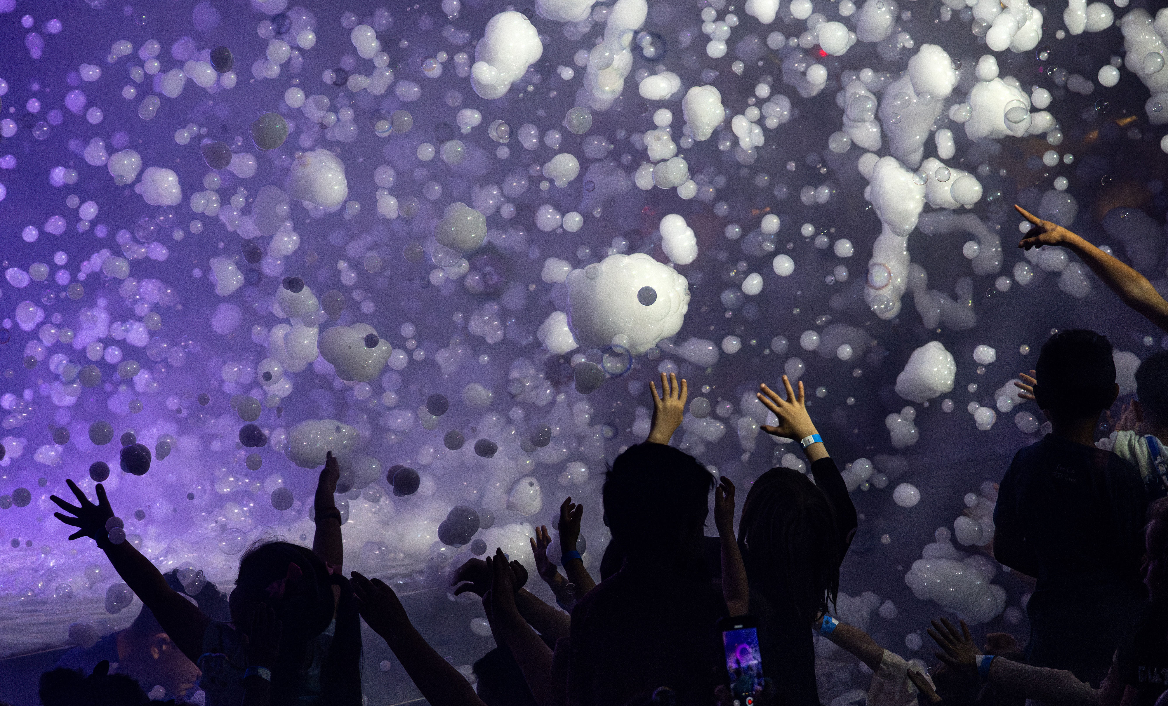 Children try to catch bubbles during Melody Yangâs Bubblefest show...