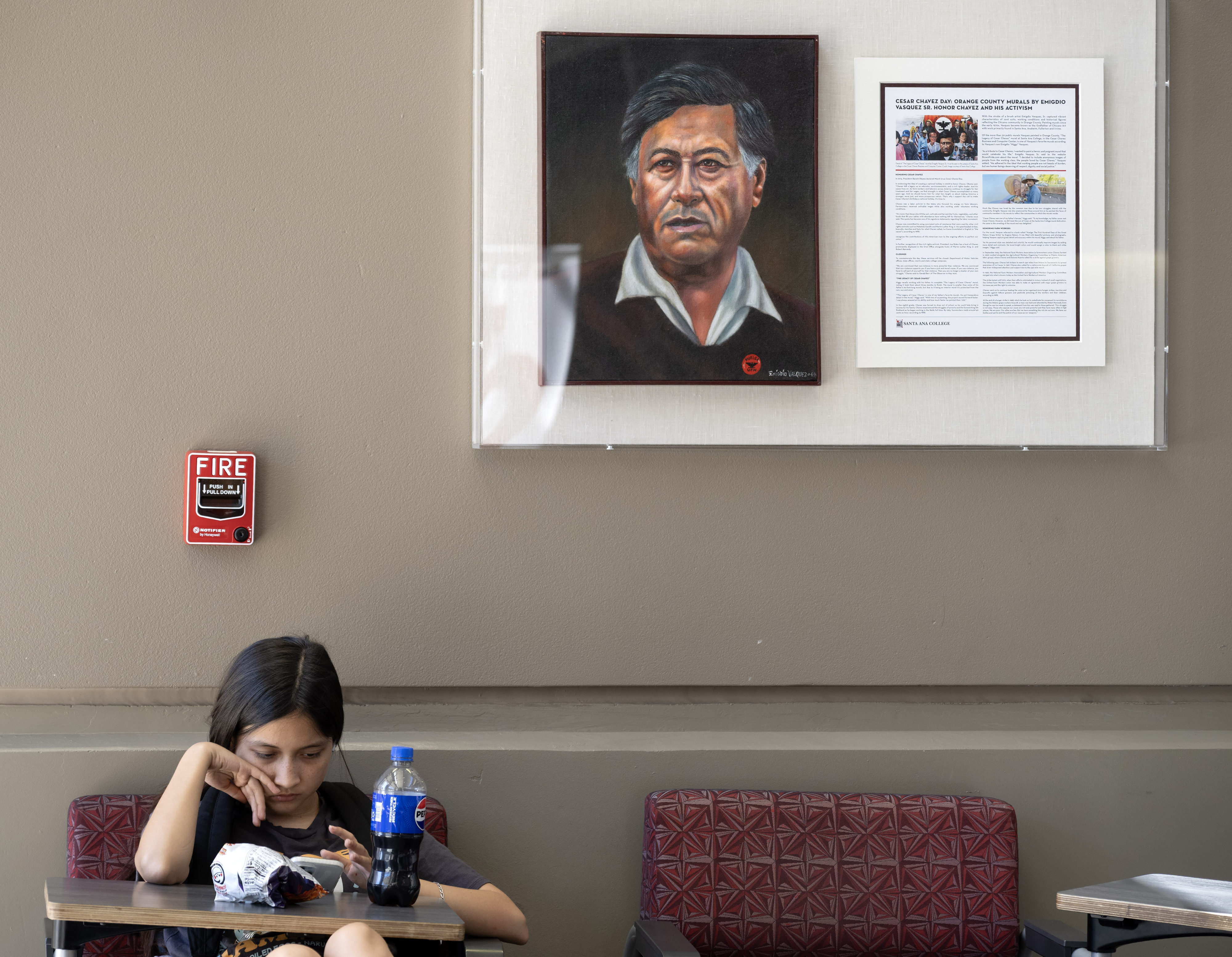 Marilyn Mendoza scans her phone as she sits under a...