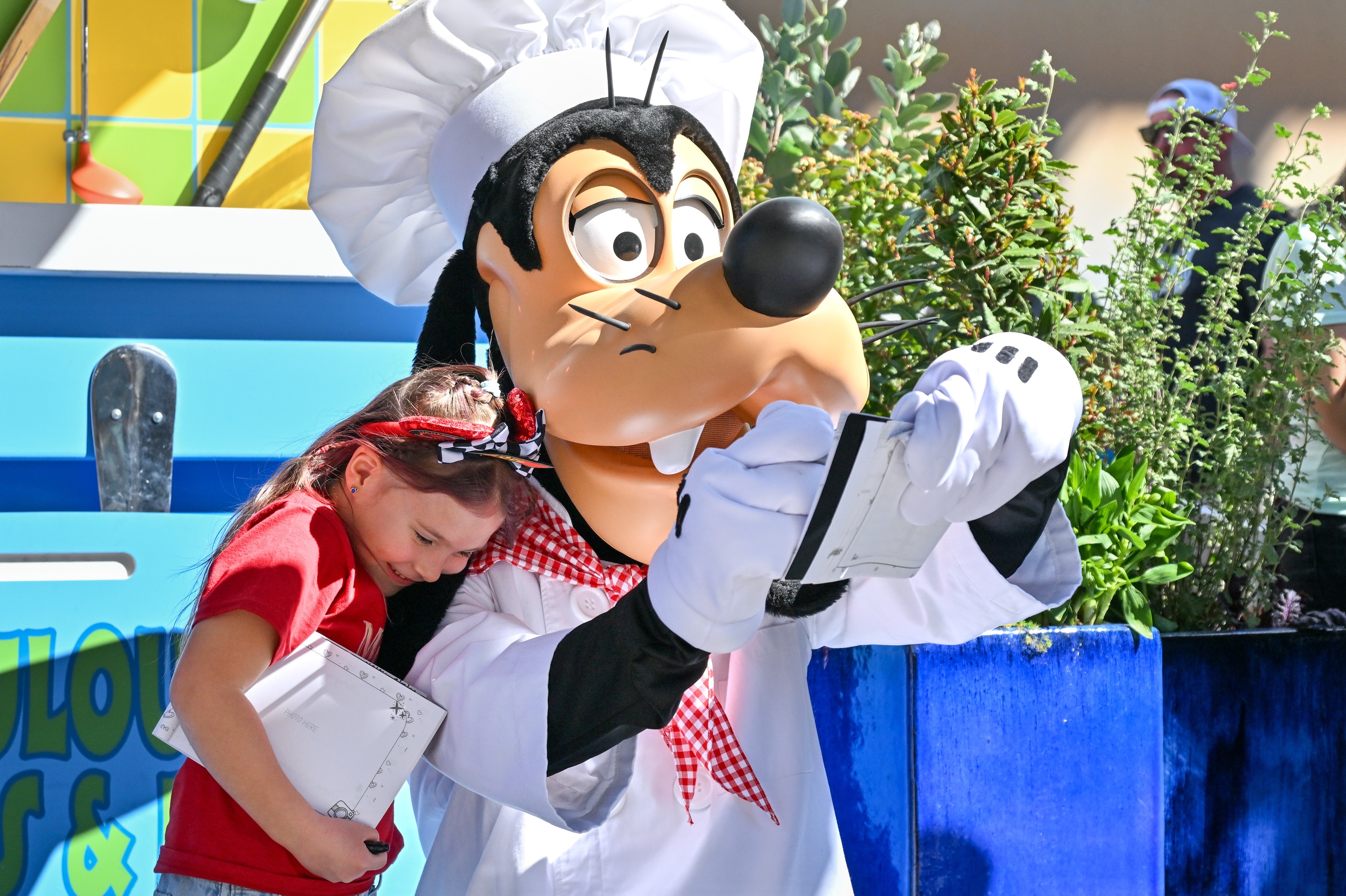 Sylver Meadows, 6, hugs Chef Goofy as he signs an...