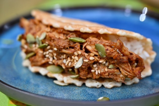 Chicken and Waffle Mole Taco; waffle taco shell filled with chicken in spicy mole sauce, white rice, pepitas and sesame seeds at Hollywood Lounge and Studio Catering Co. in Hollywood Land during the California Food & Wine Festival inside California Adventure running March 6 through April 27, 2026. Photographed on Friday, March 6, 2026. (Photo by Jeff Gritchen, Orange County Register/SCNG)