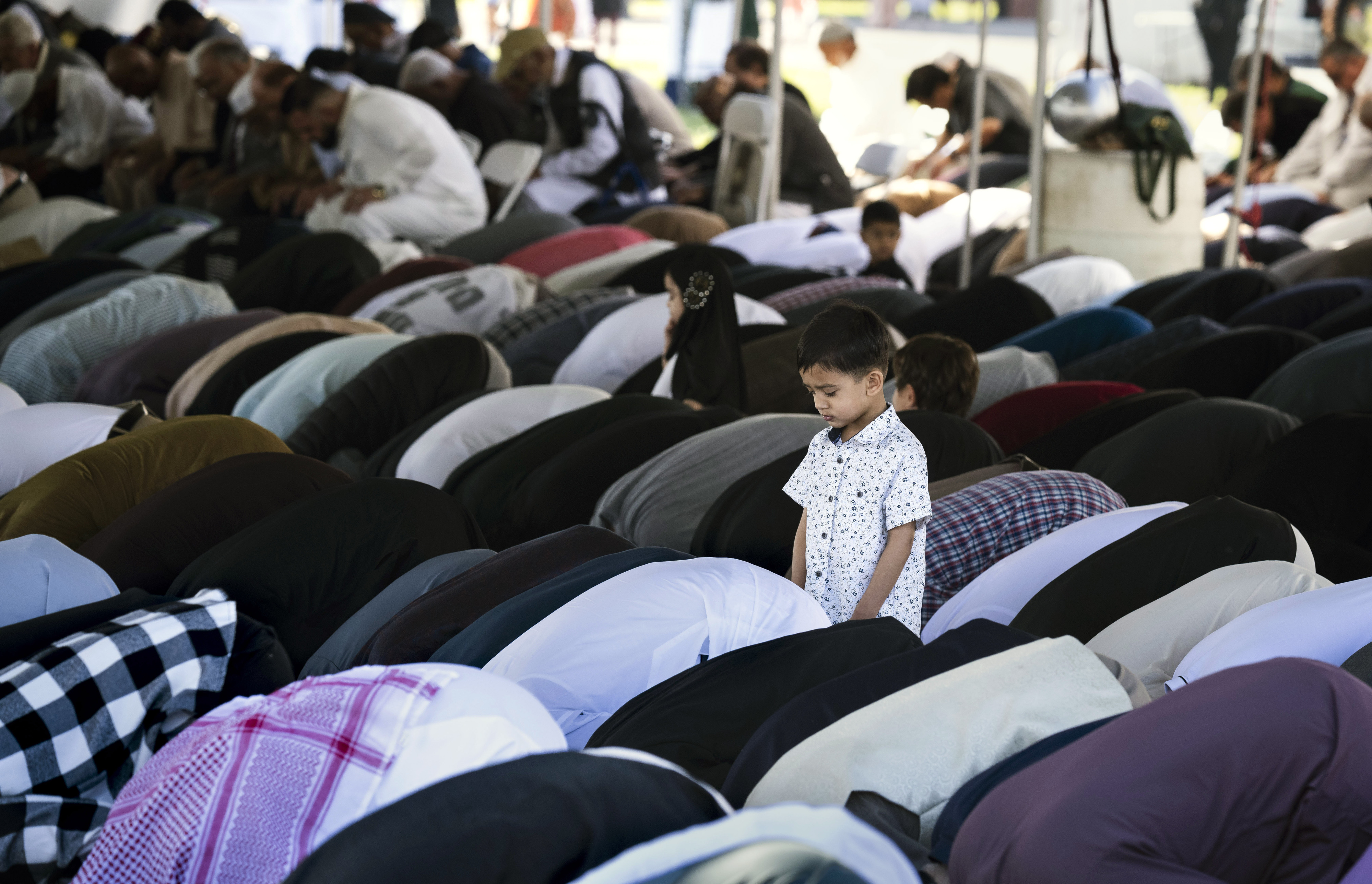 Men, and a boy, pray during an Eid ul-Fitr celebration...