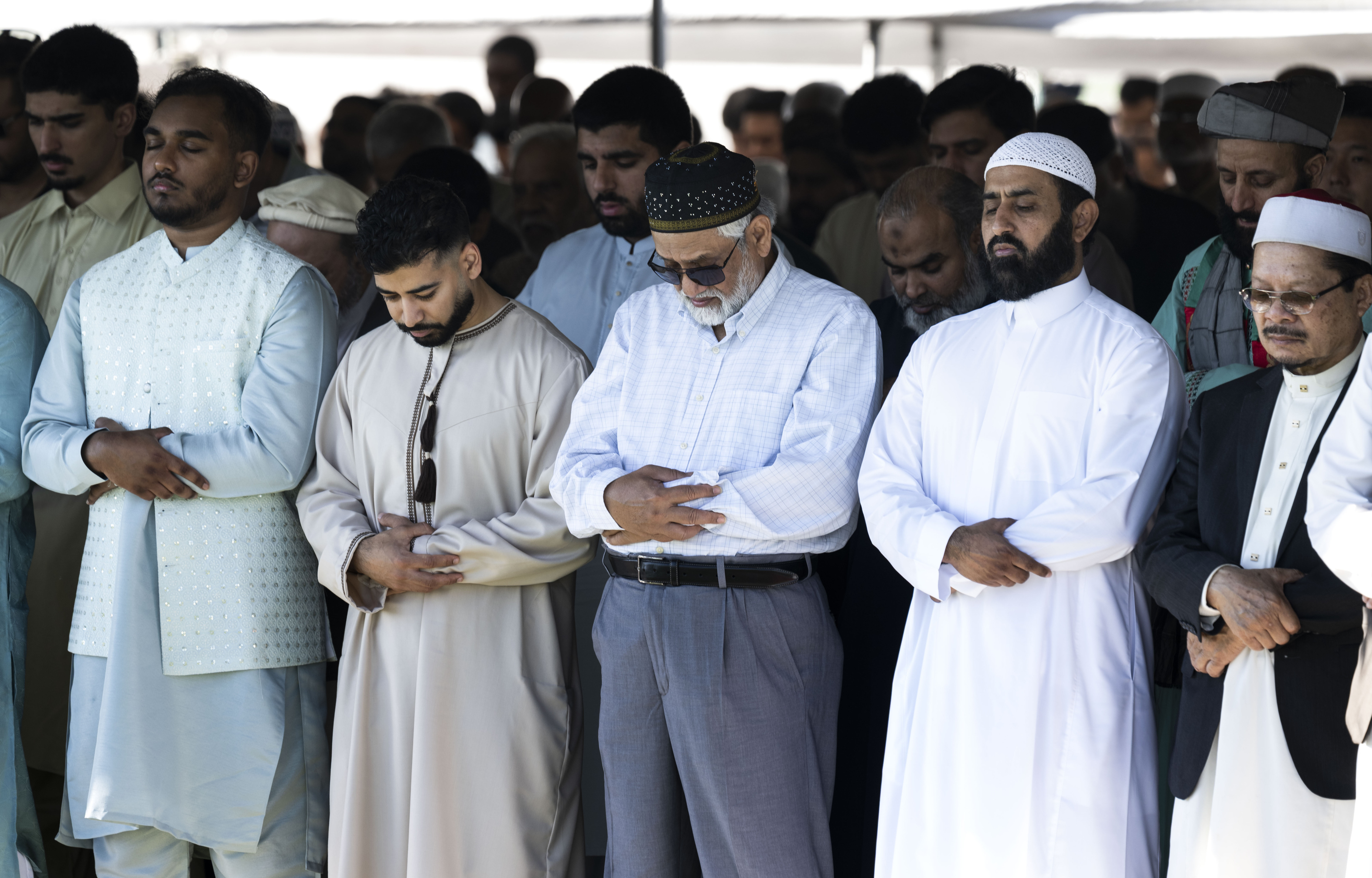 Men pray during an Eid ul-Fitr celebration in Garden Grove,...