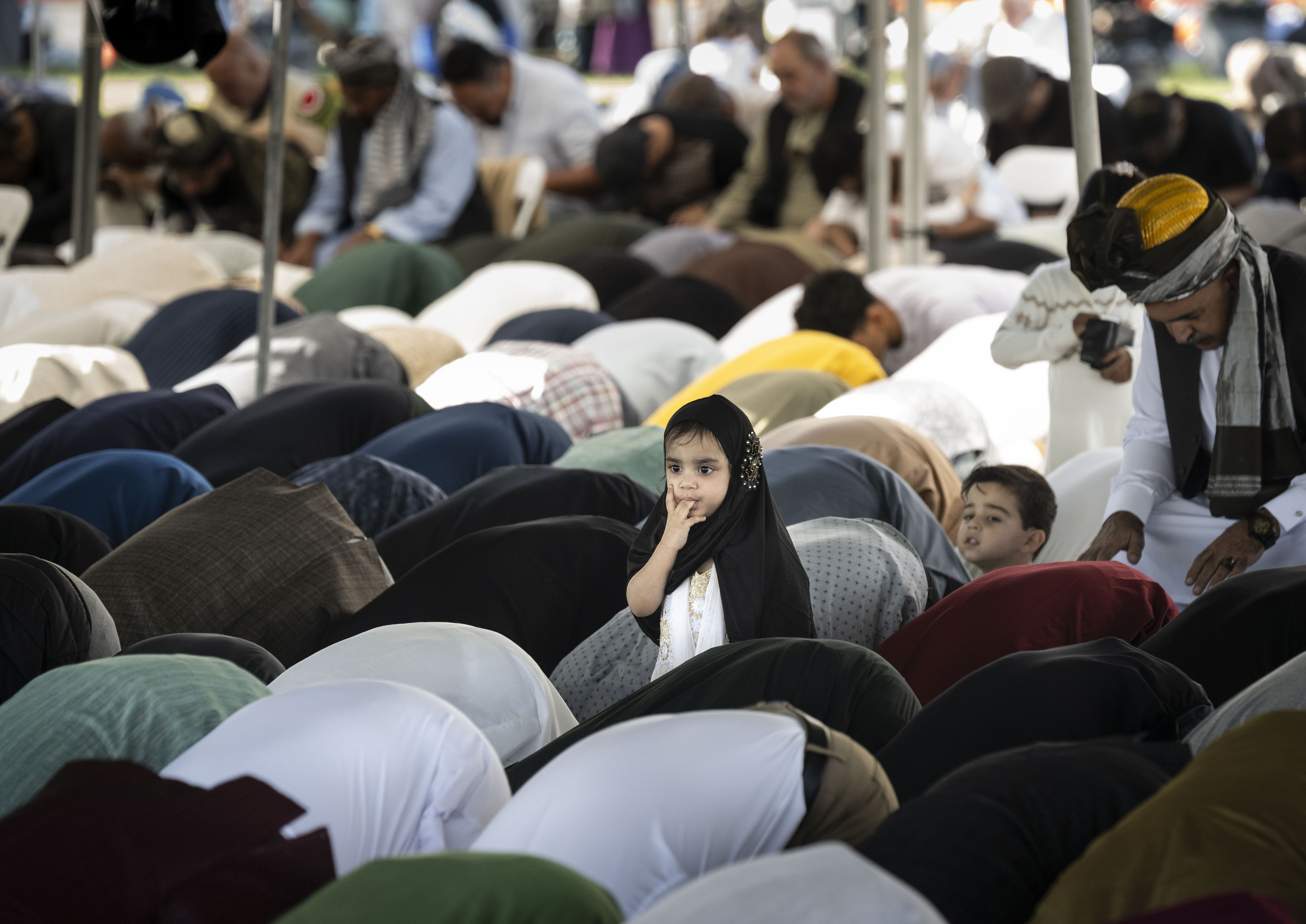 Men pray during an Eid ul-Fitr celebration in Garden Grove,...