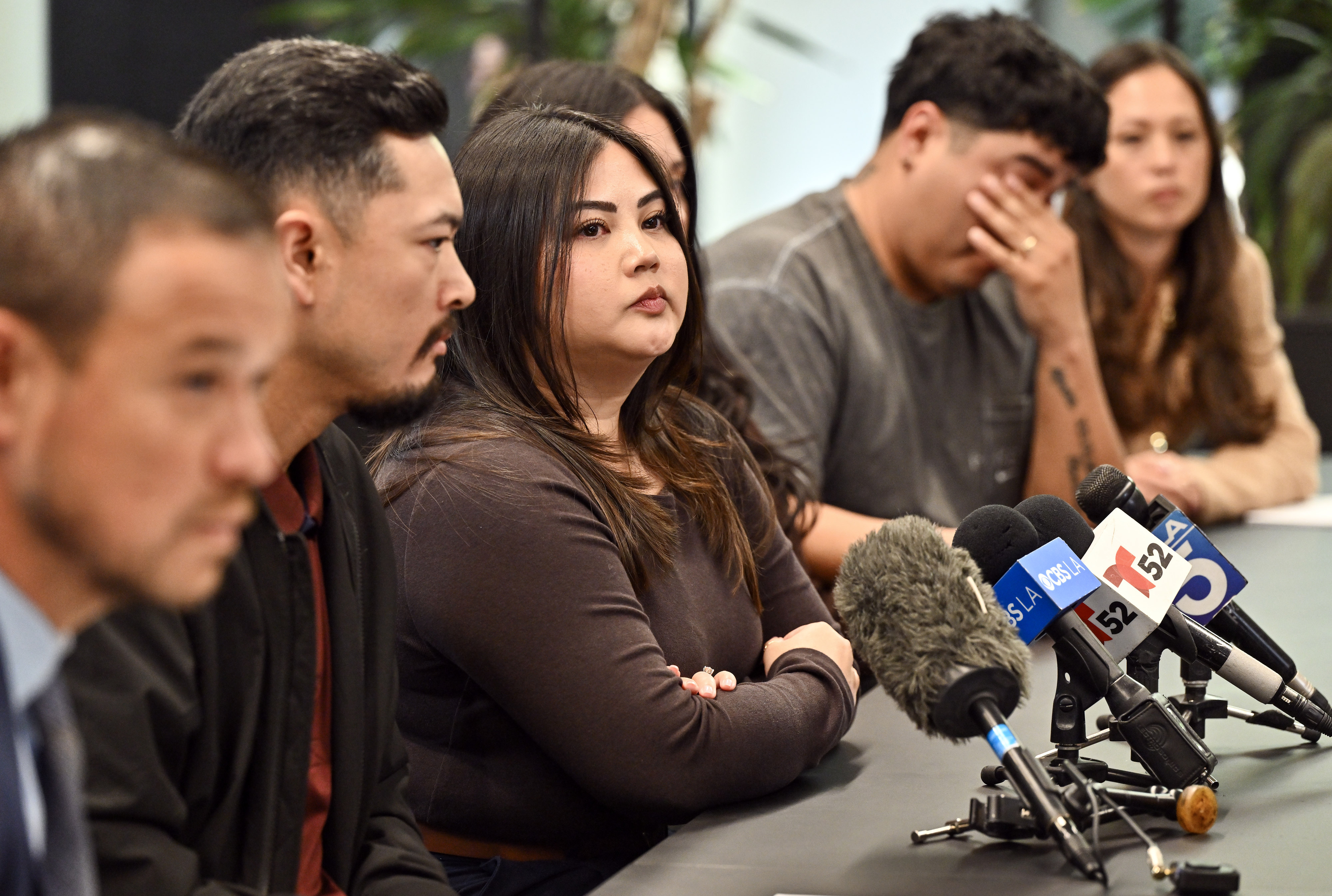 Monique Santos, center, and Mikhael Allen Santos, left, join other...
