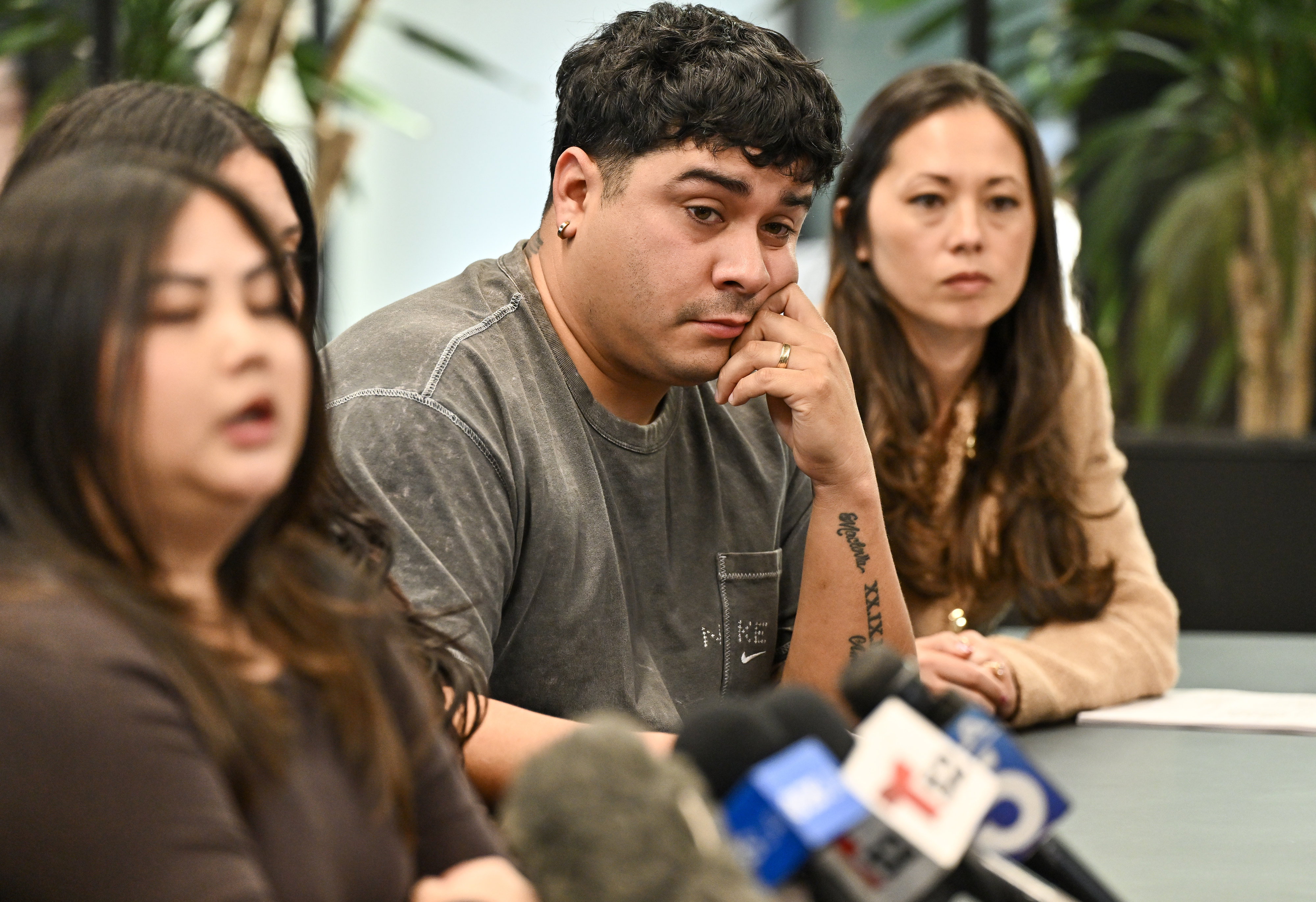 Jorge Reyes listens as fellow plaintiffs speak to the media...