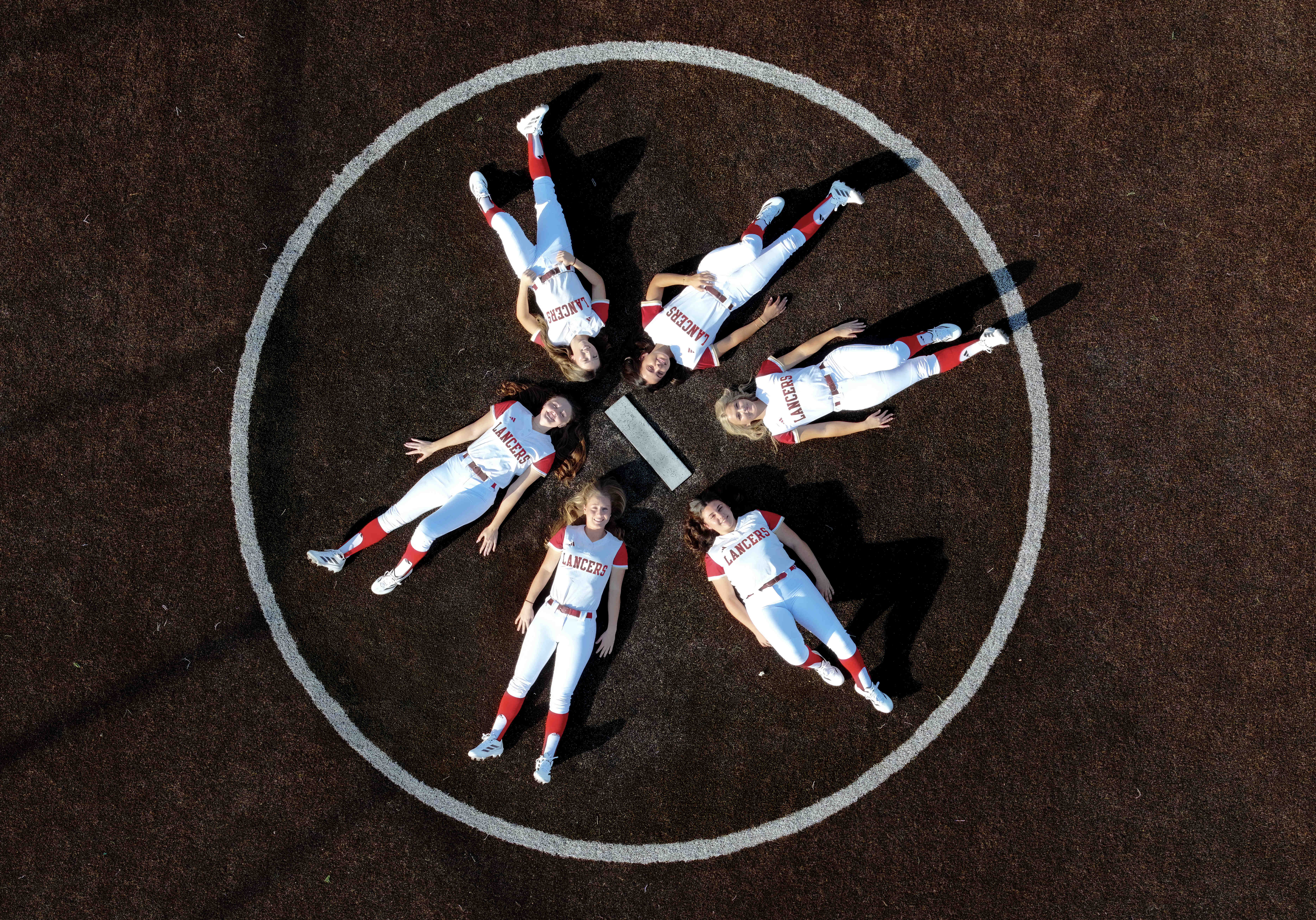 Orange Lutheran softball players, clockwise from bottom center, Carlie Snyder,...