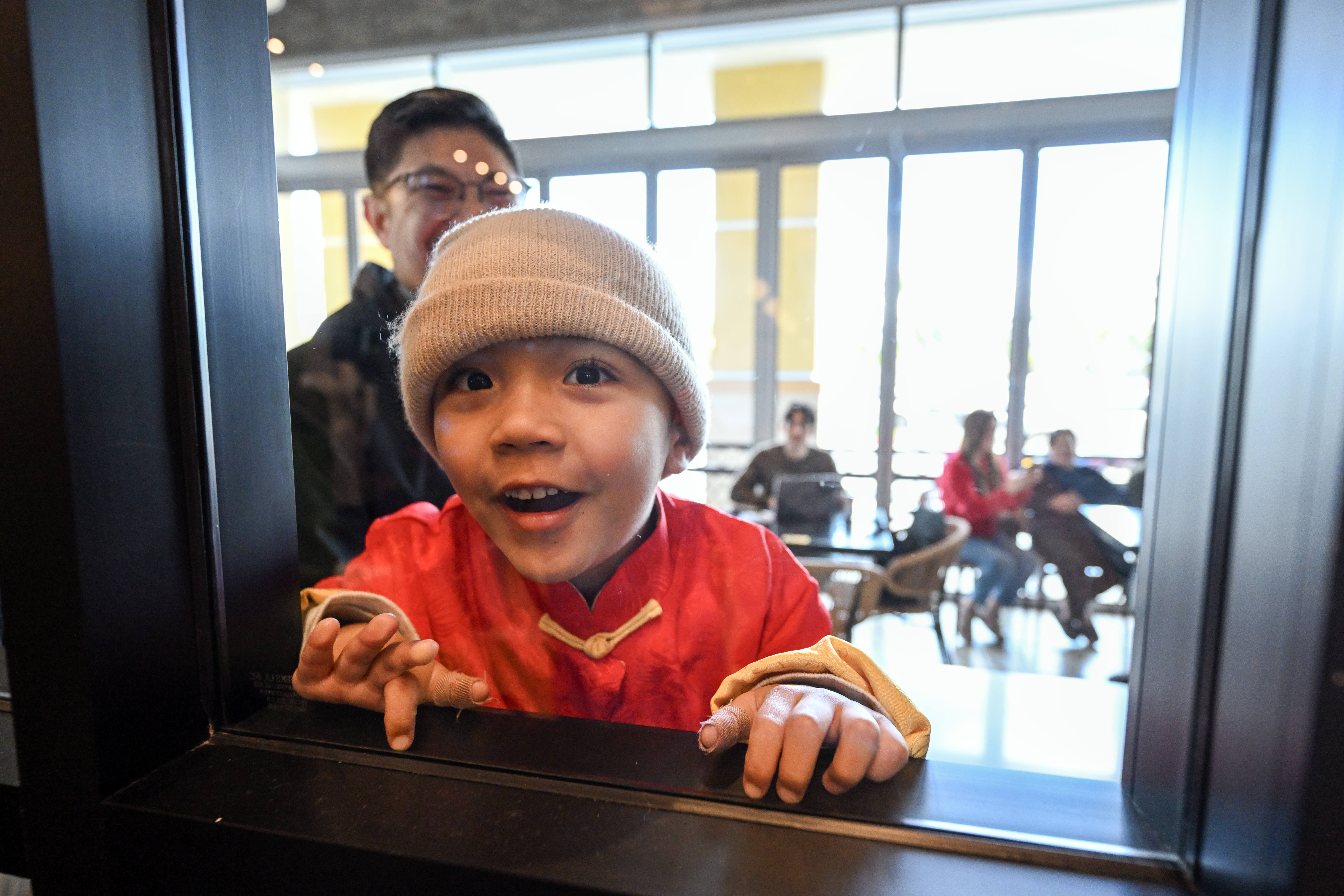 Wyatt Sullivan, 3, peers thrpough an interior window as Ane...