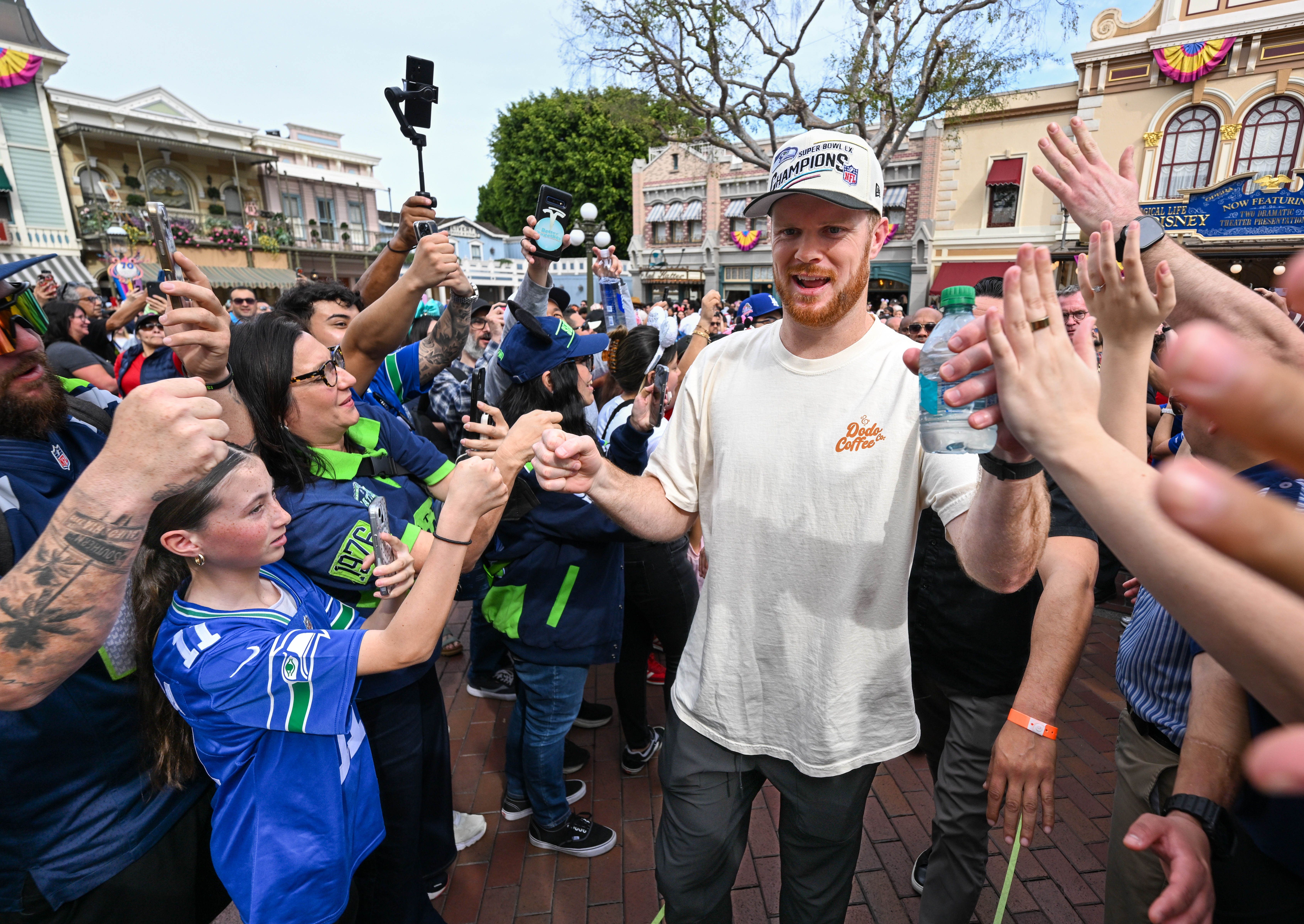 Seahawk quarterback Sam Darnold makes his way through Disneyland guests...