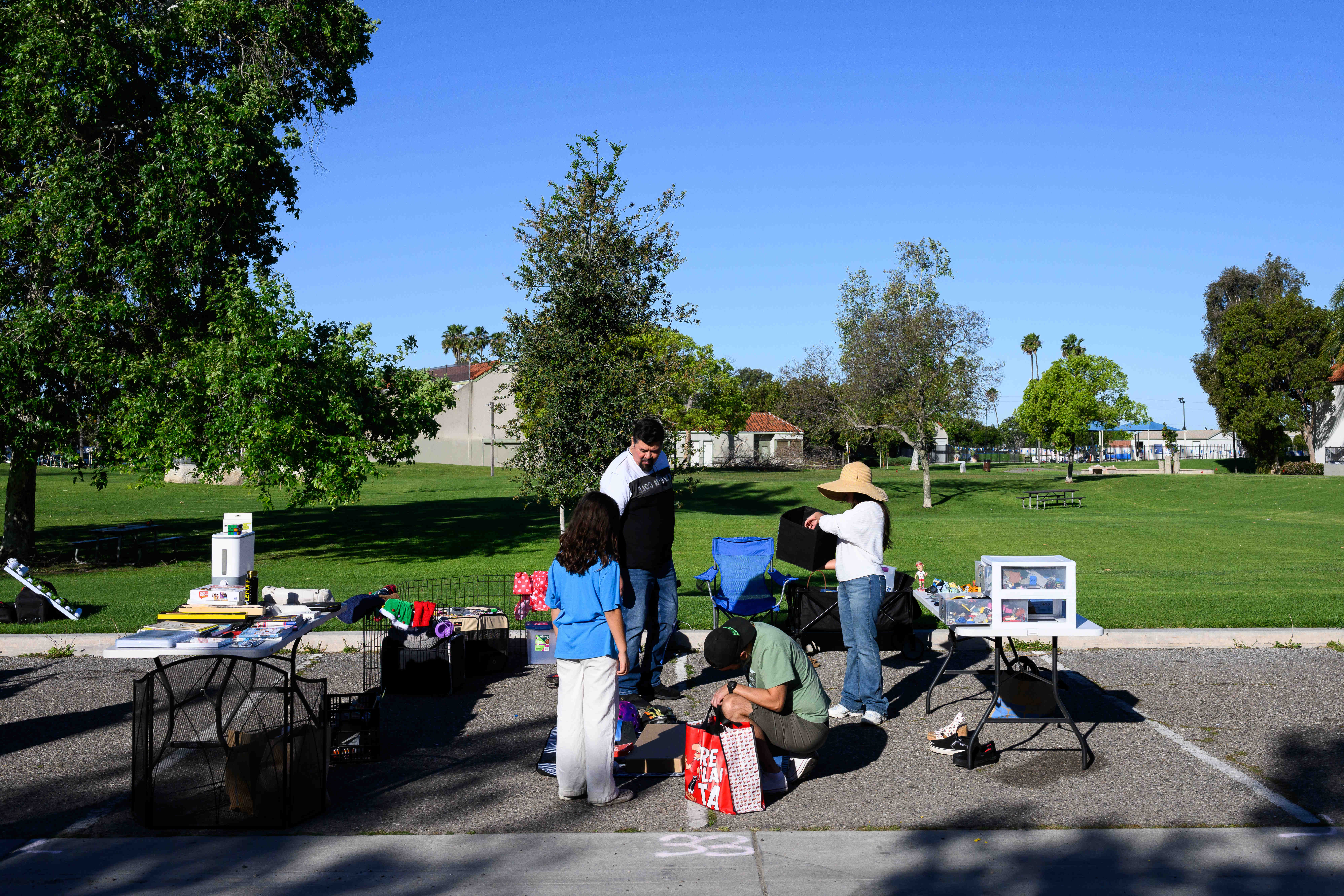 People browse a stand during a community yard sale held...