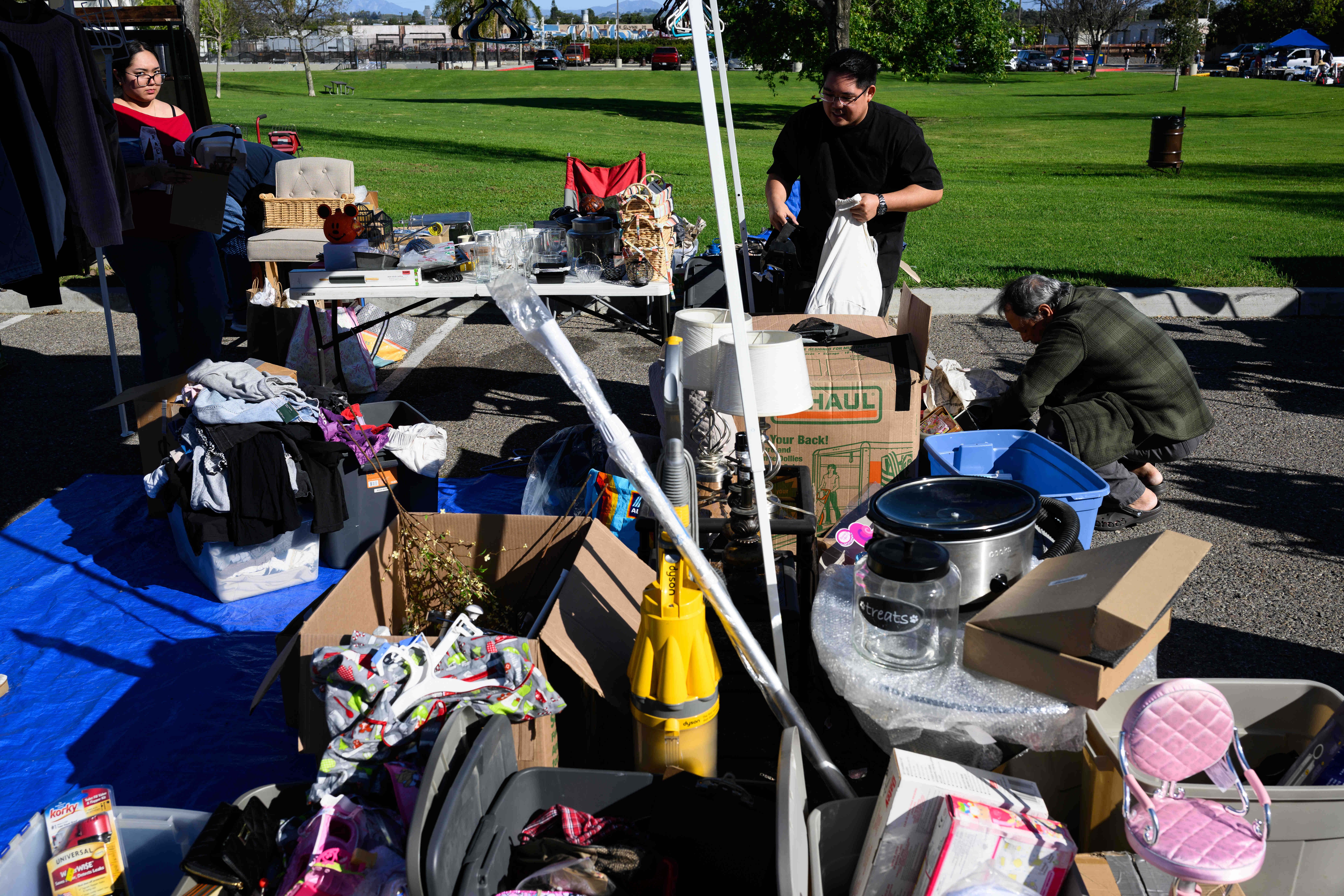 People look through boxes of items that are being sold...