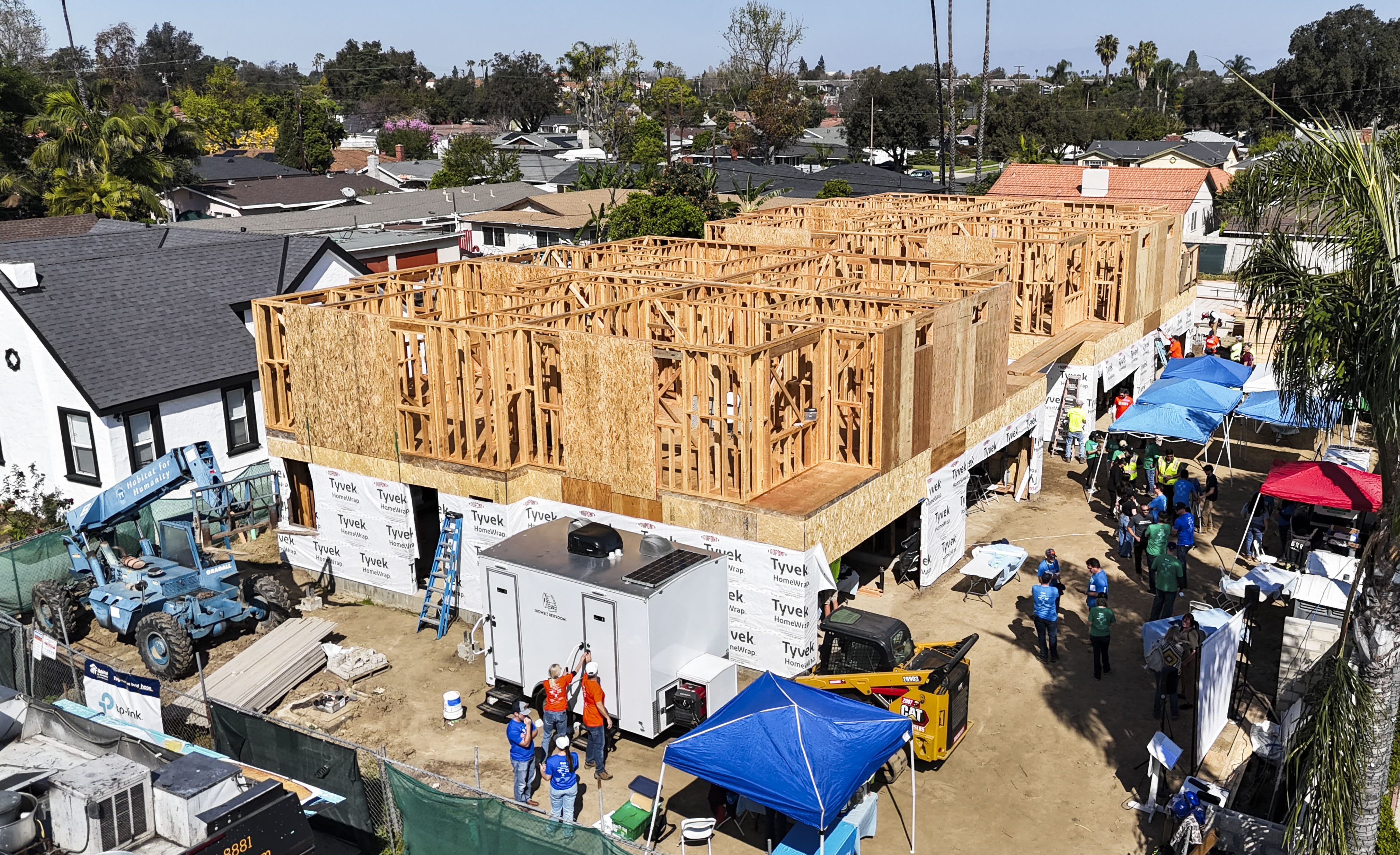 Workers and volunteers construct homes during the 17th Annual Leaders...
