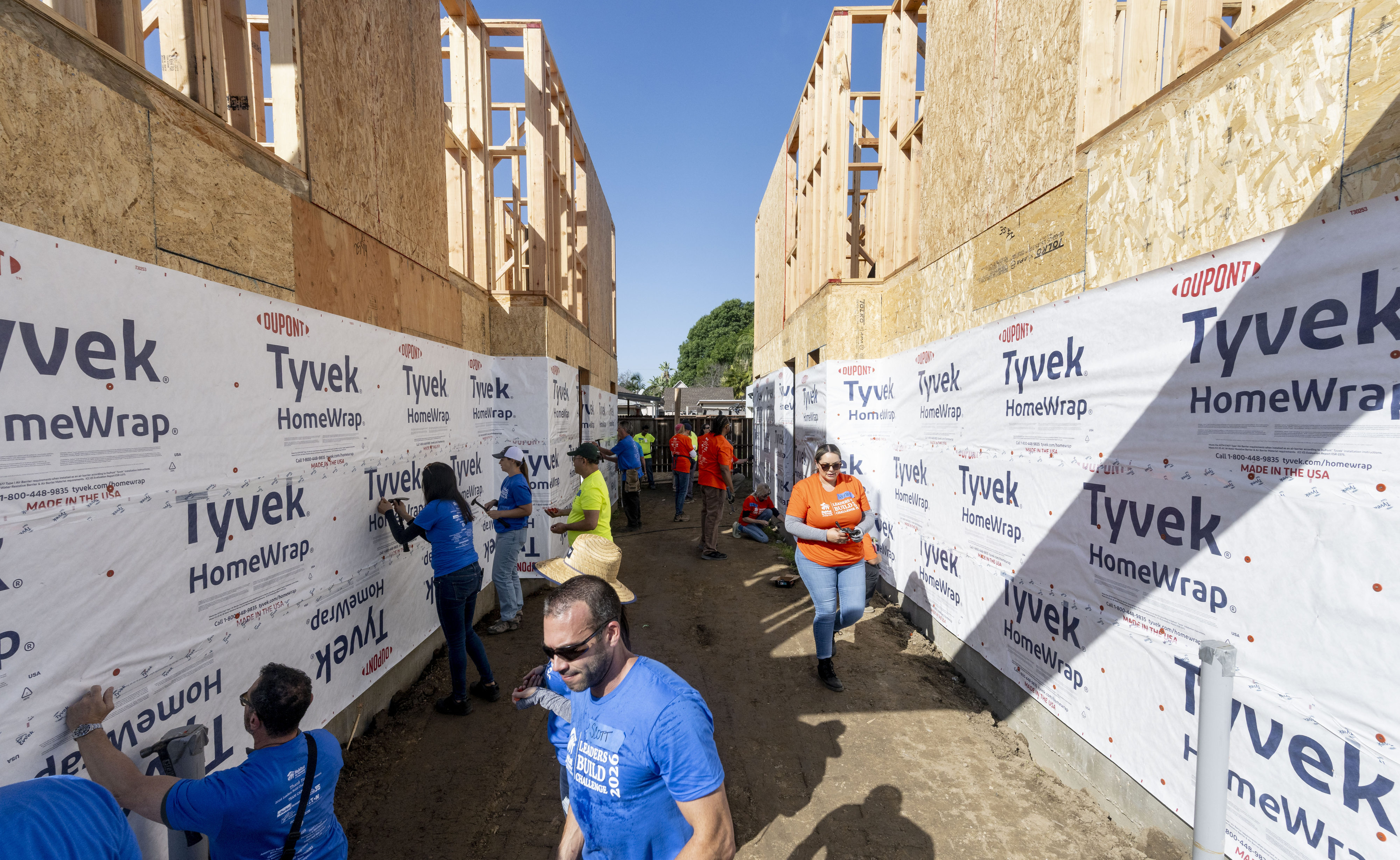 Workers and volunteers construct homes during the 17th Annual Leaders...