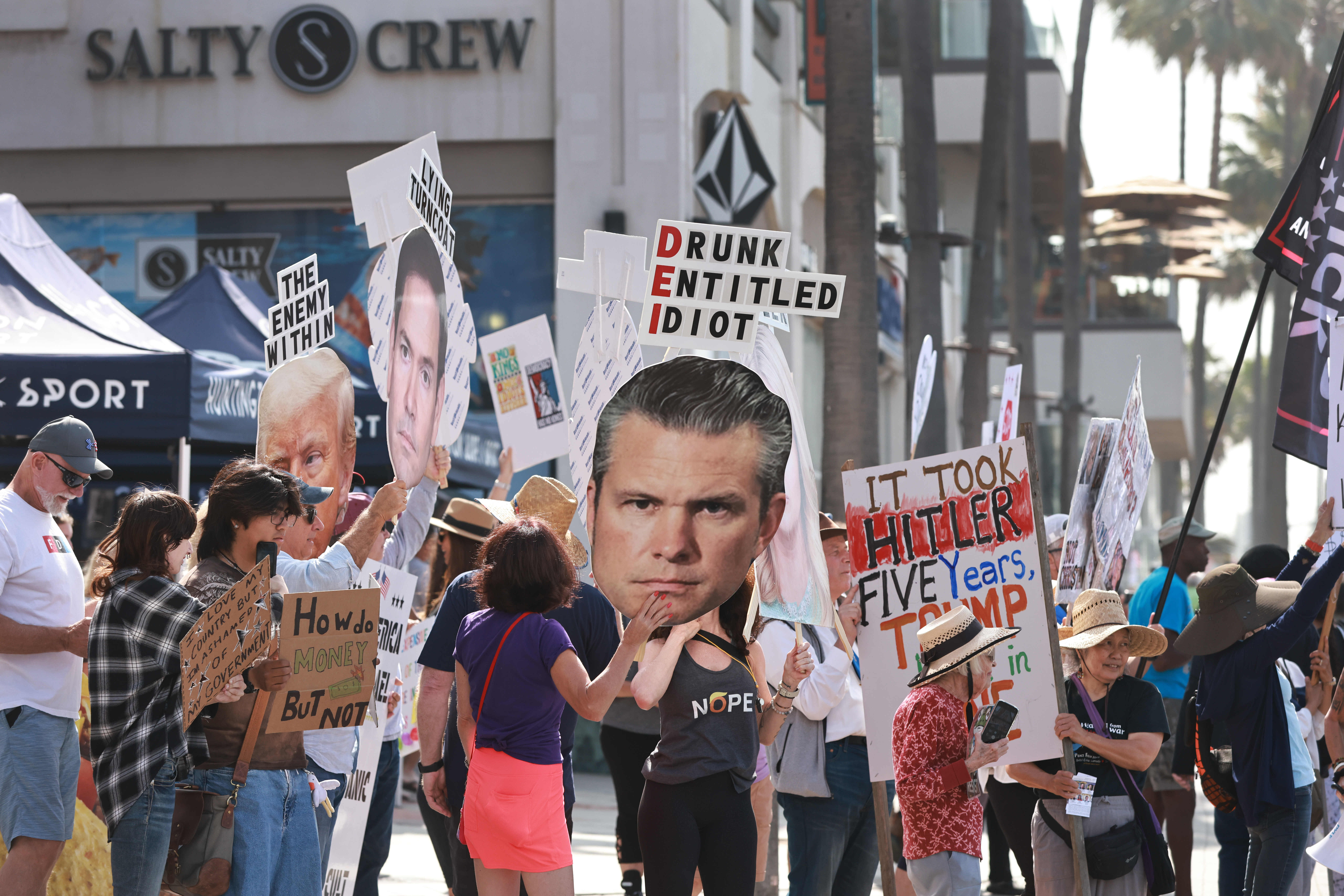 Signs at the “No Kings” protest at the Huntington Beach...